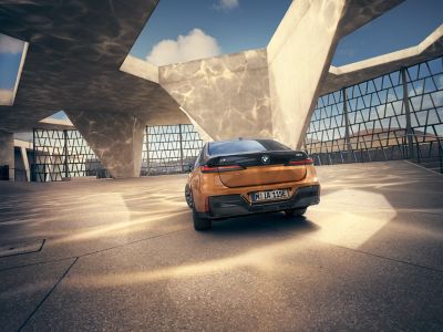 BMW i7 M70 xDrive orange rear view 