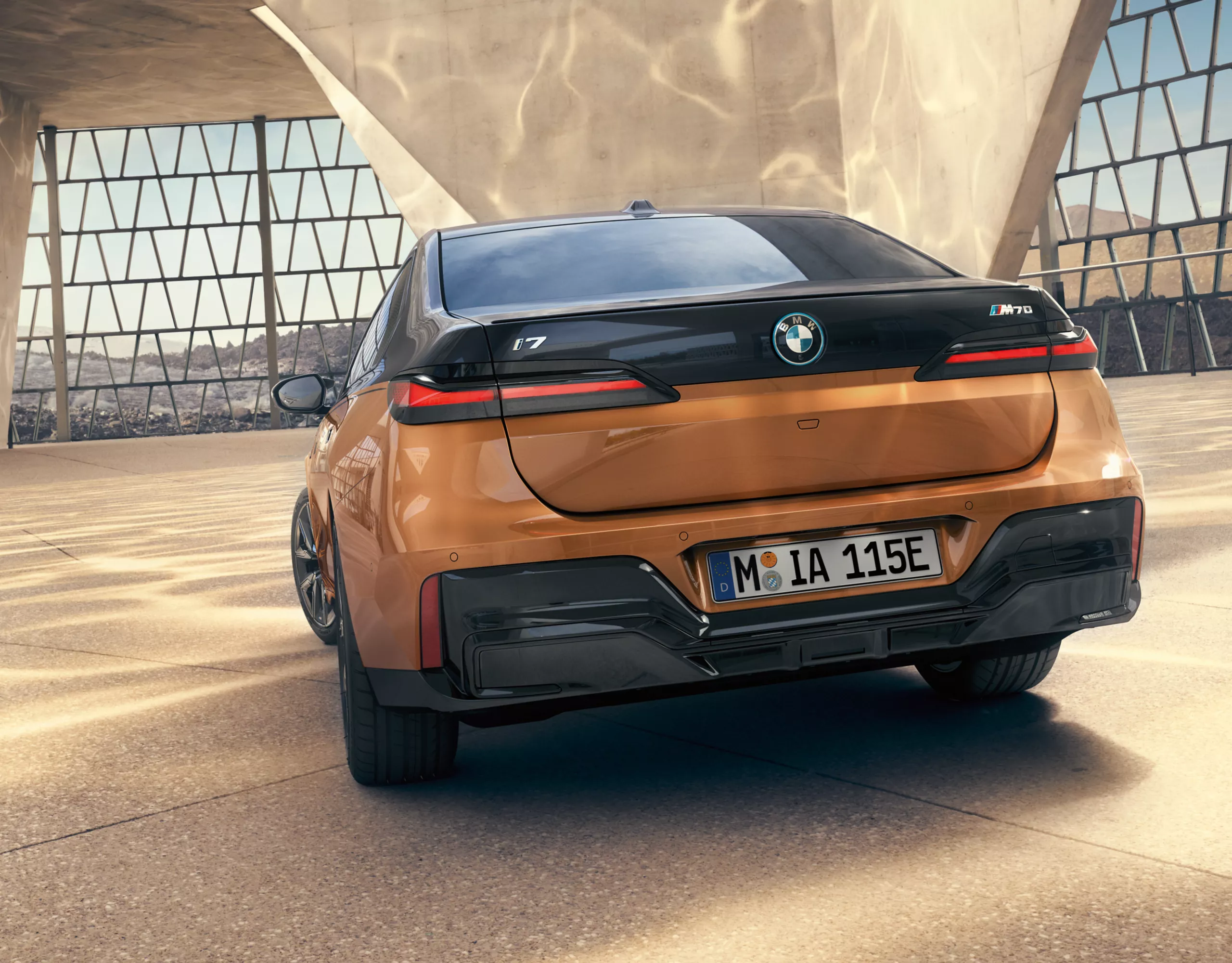 BMW i7 M70 xDrive orange rear view 