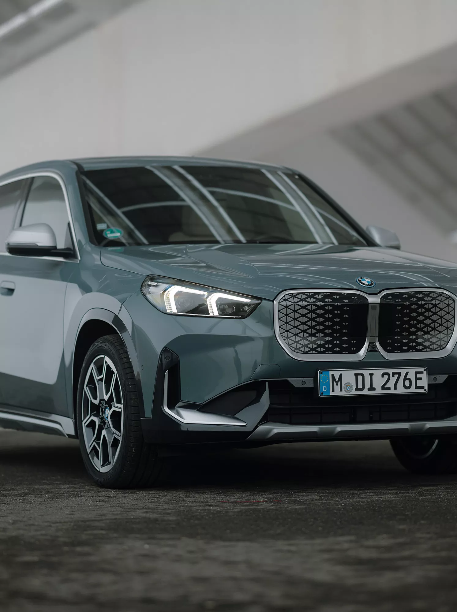 En blå BMW iX1 sedd snett framifrån