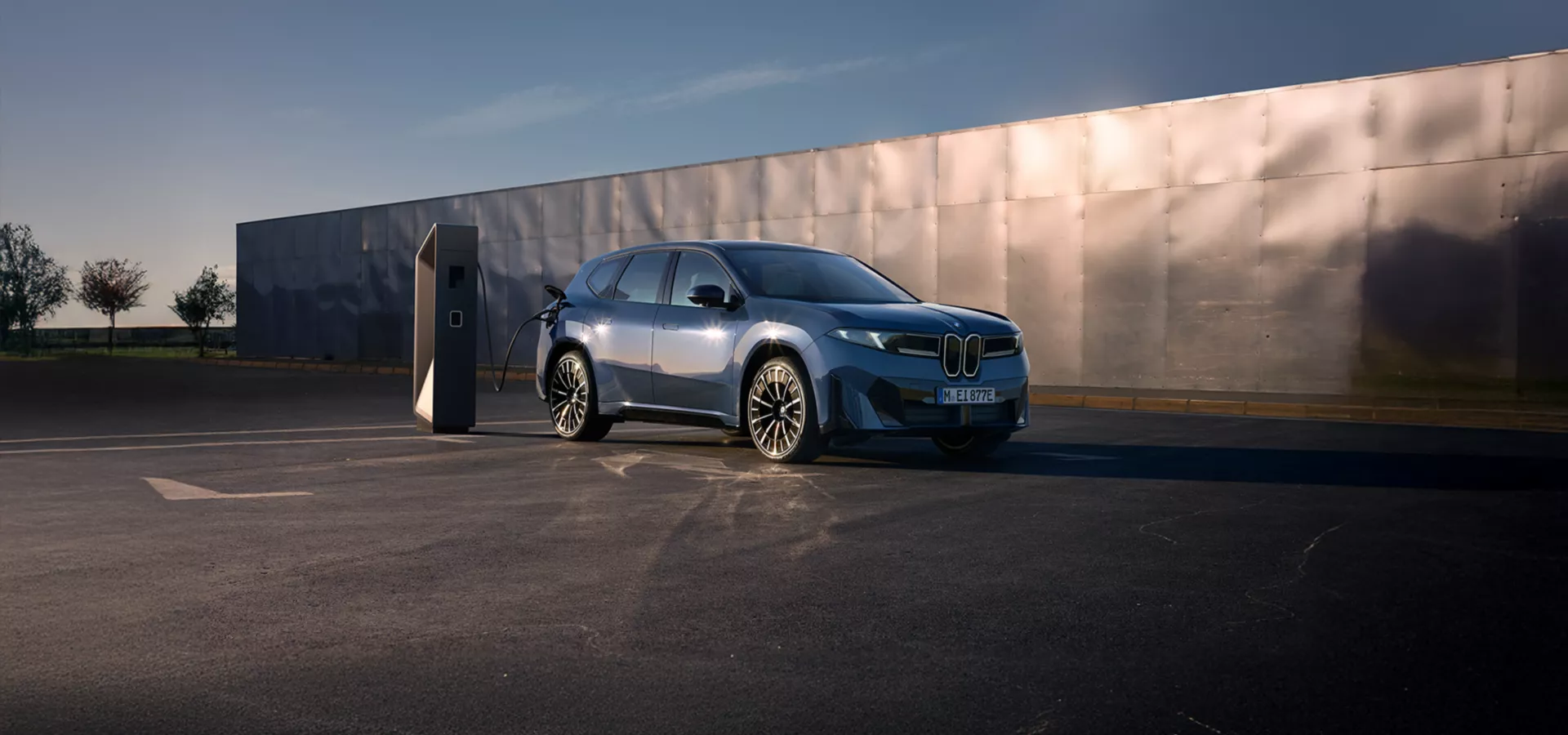 Neuer BMW iX3 in Blau an einer Ladestation