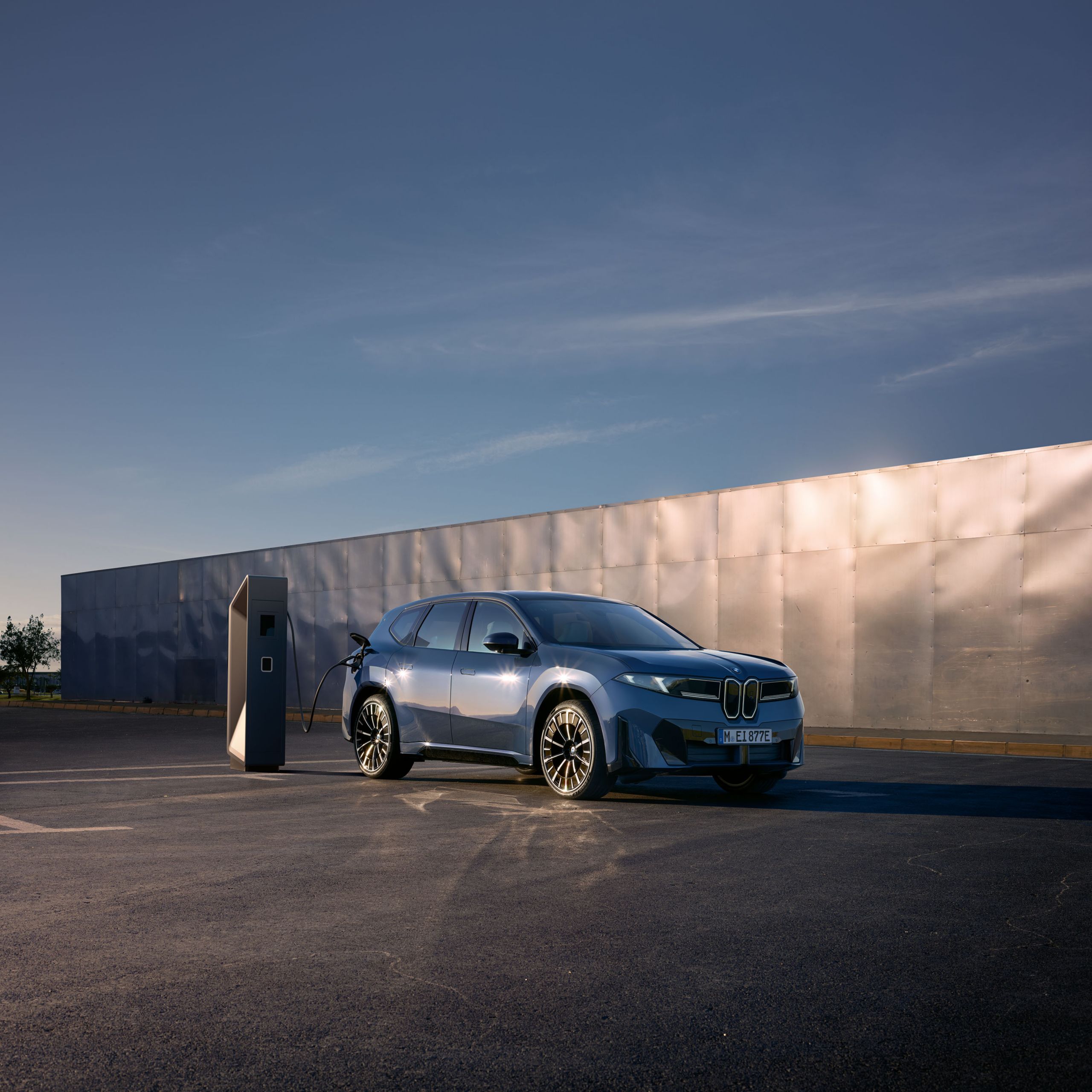 En blå BMW iX3 parkerad som laddas