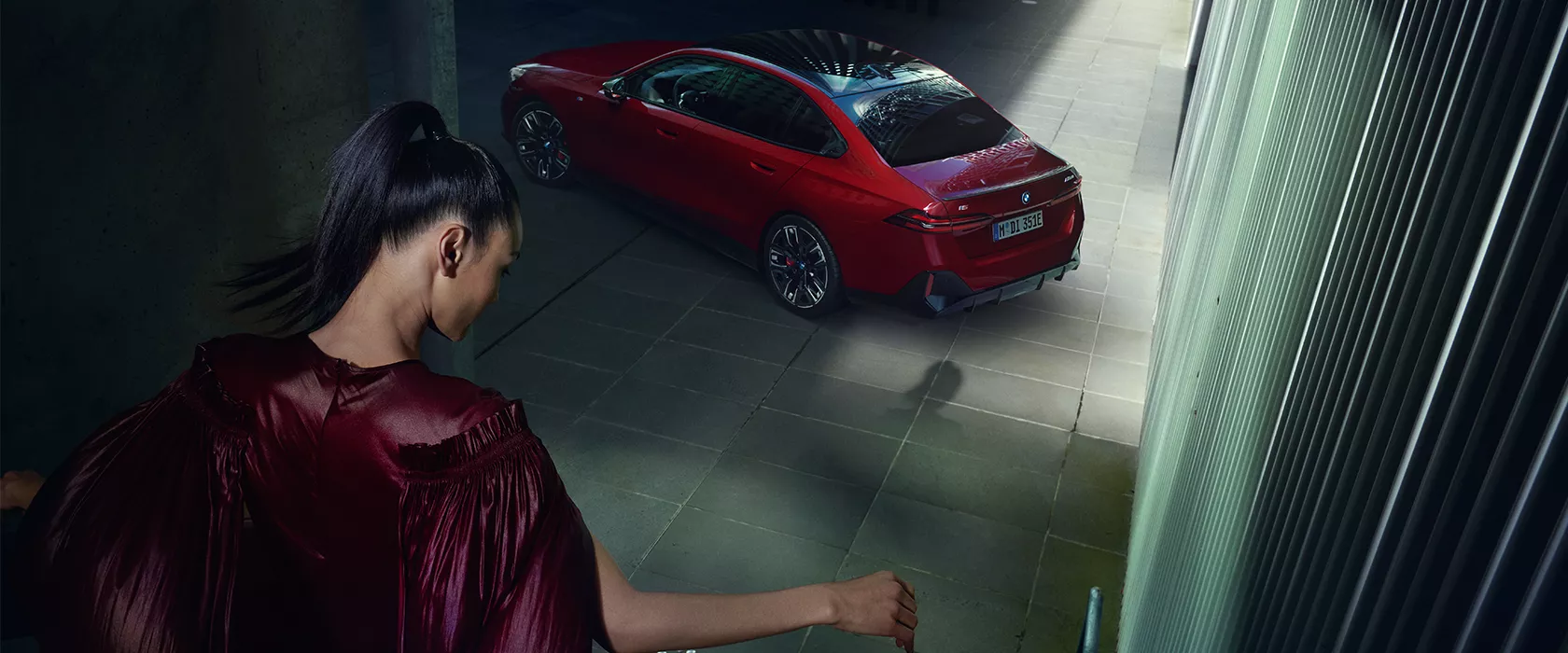 Woman walking towards a red BMW