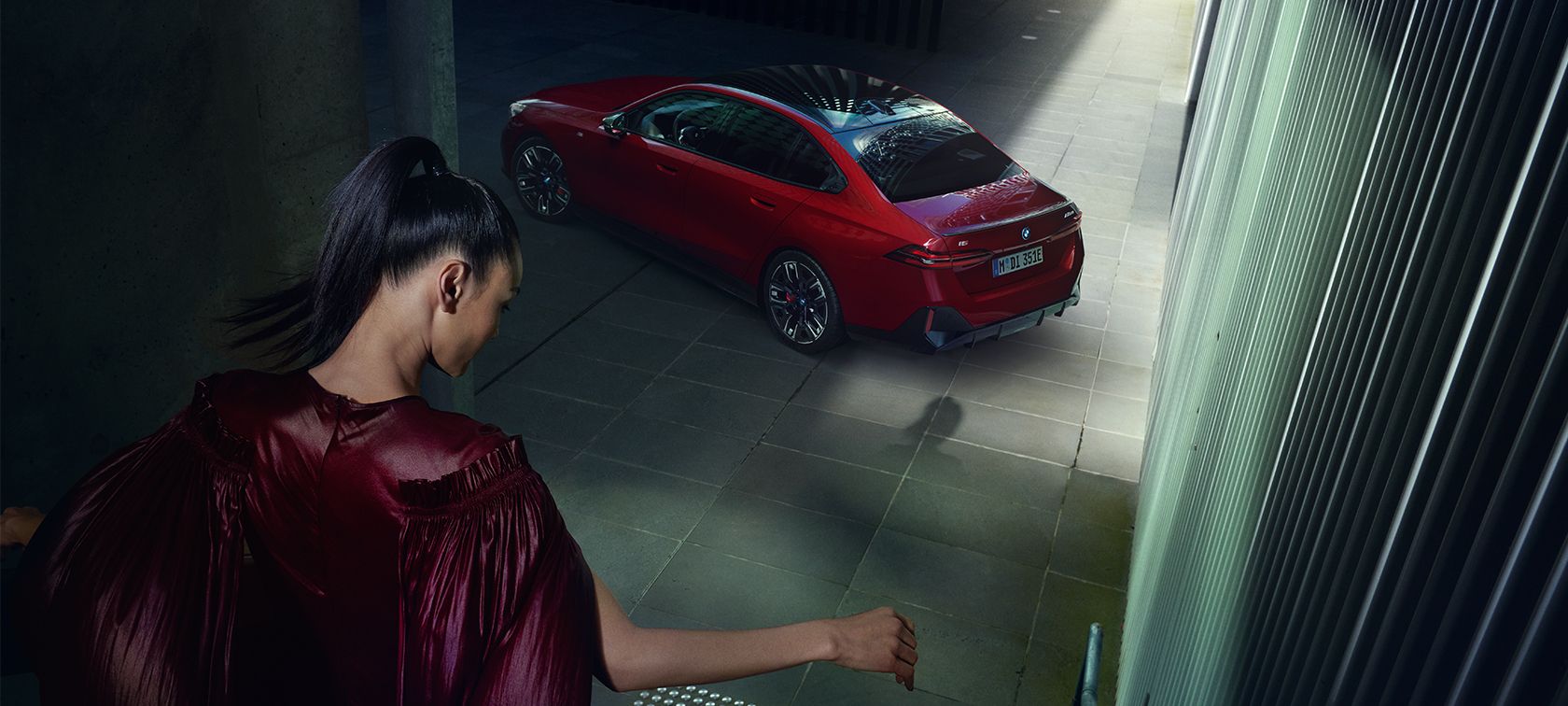 Woman walking towards a red BMW