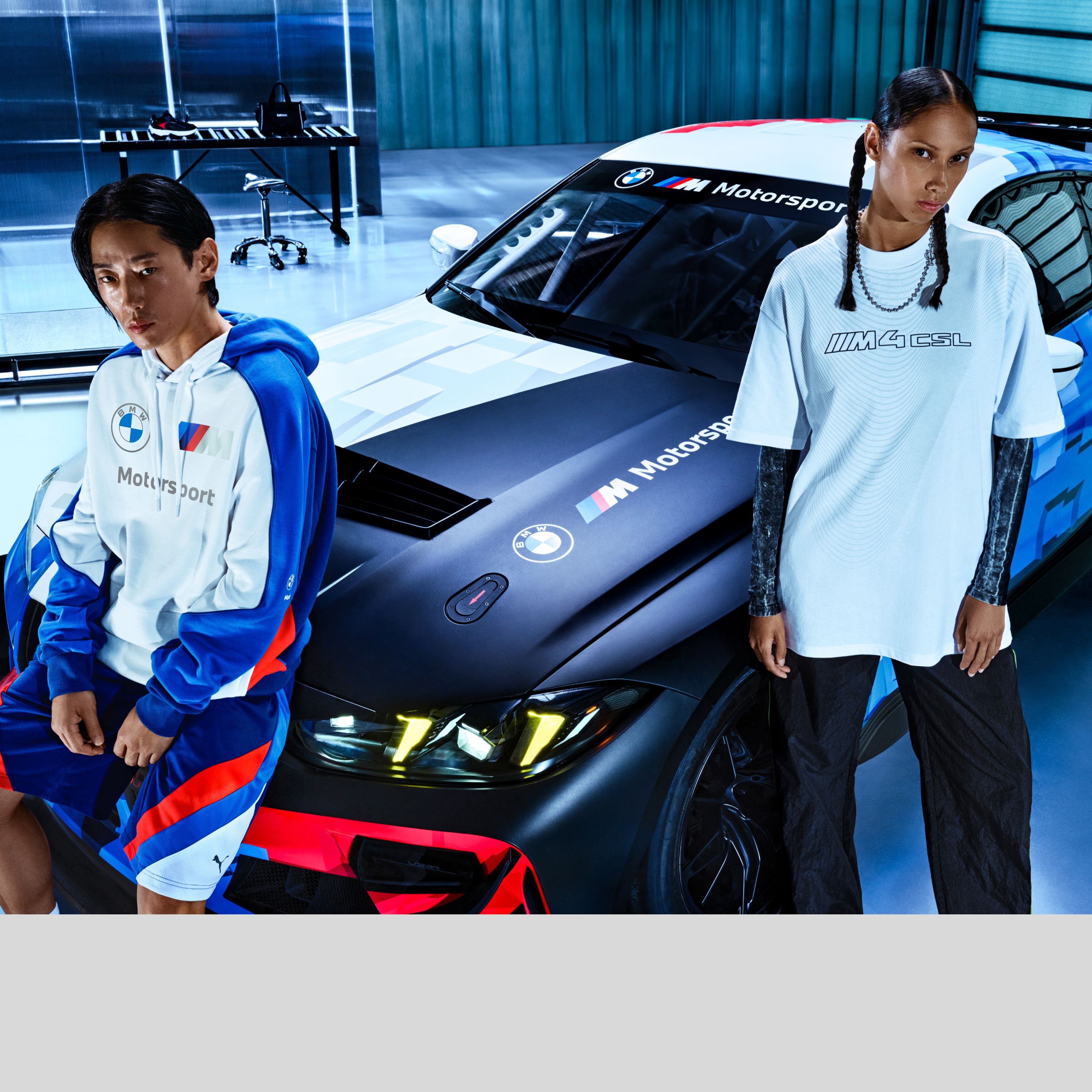 Collezione BMW M Motorsport BMW Lifestyle con felpa, pantaloncini e t-shirt indossati da due giovani
