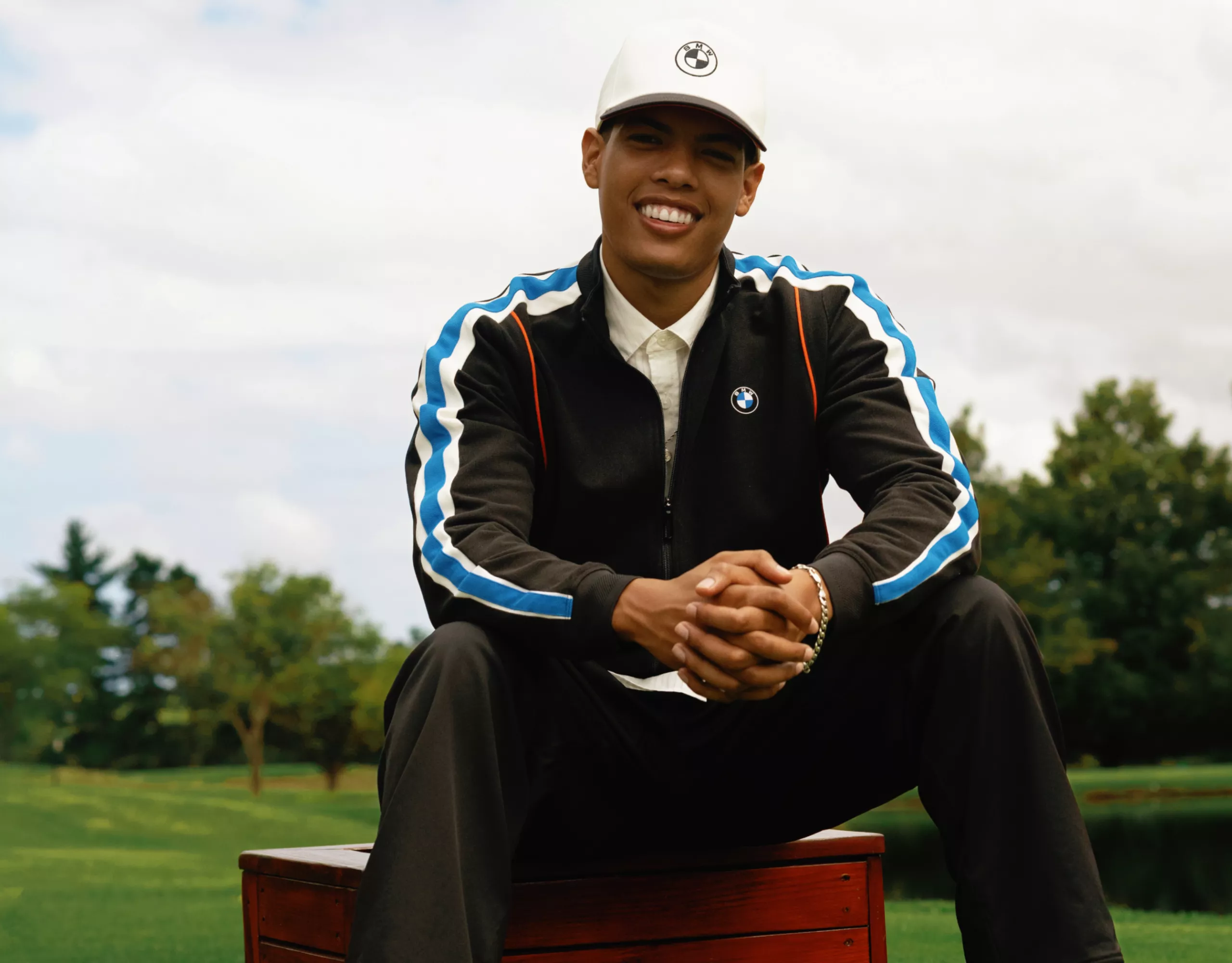 Tracksuit and baseball cap with BMW logo, worn by a young man