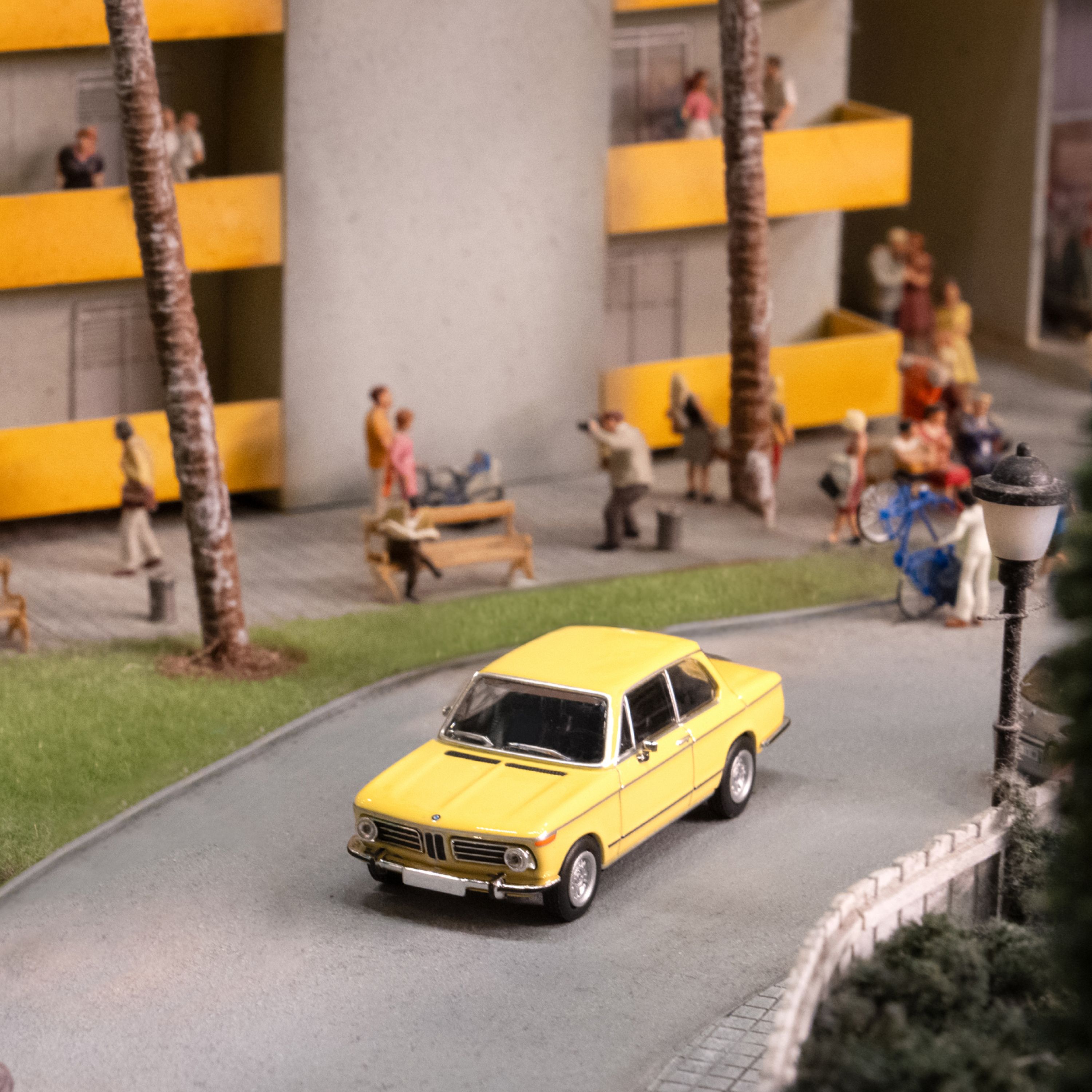 Modellino BMW 02 BMW Lifestyle in giallo in un mondo in miniatura