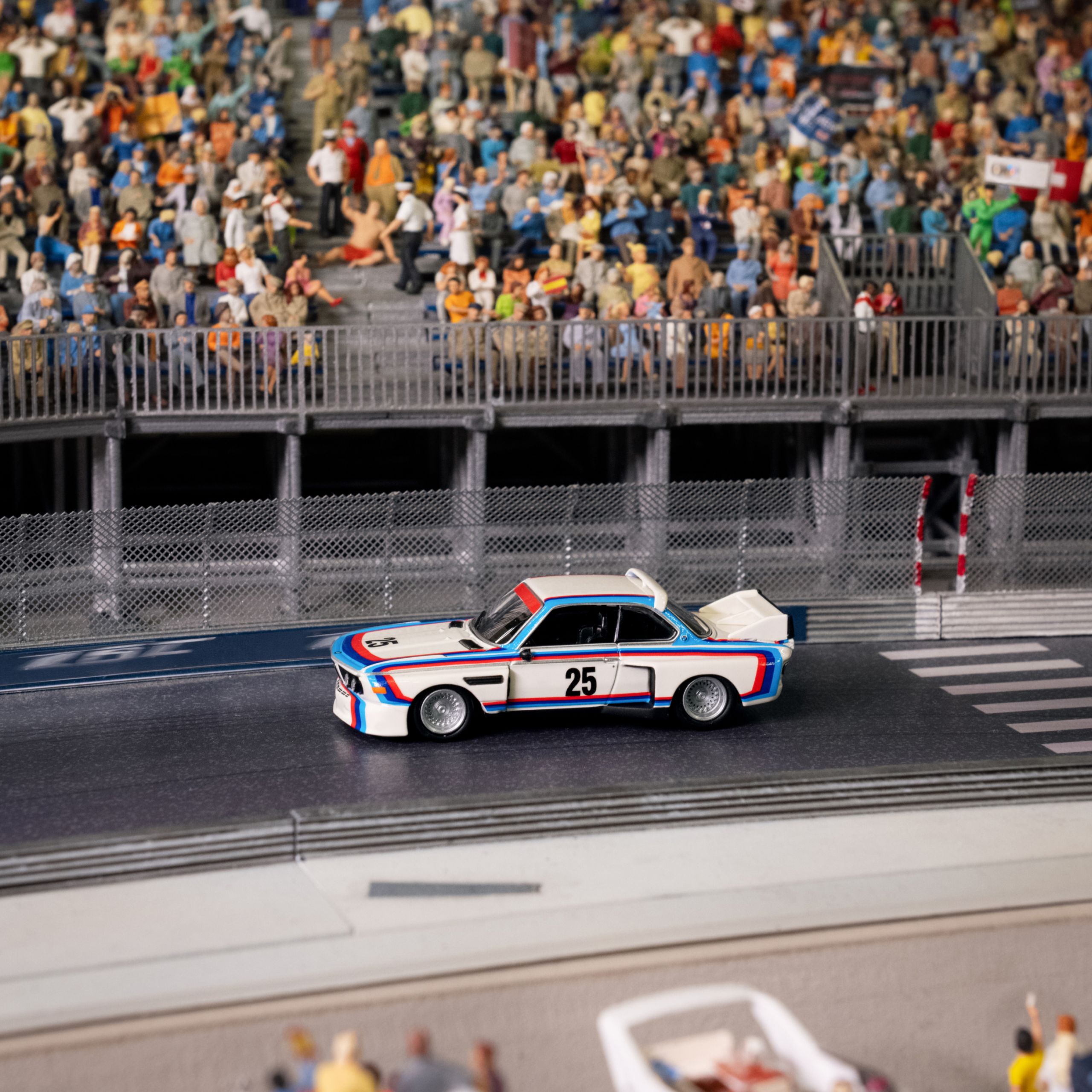 BMW Lifestyle BMW M3 E30 miniatura s pruhy od Wolfganga Seehause a číslem 25 na panelu dveří na miniaturní závodní dráze
