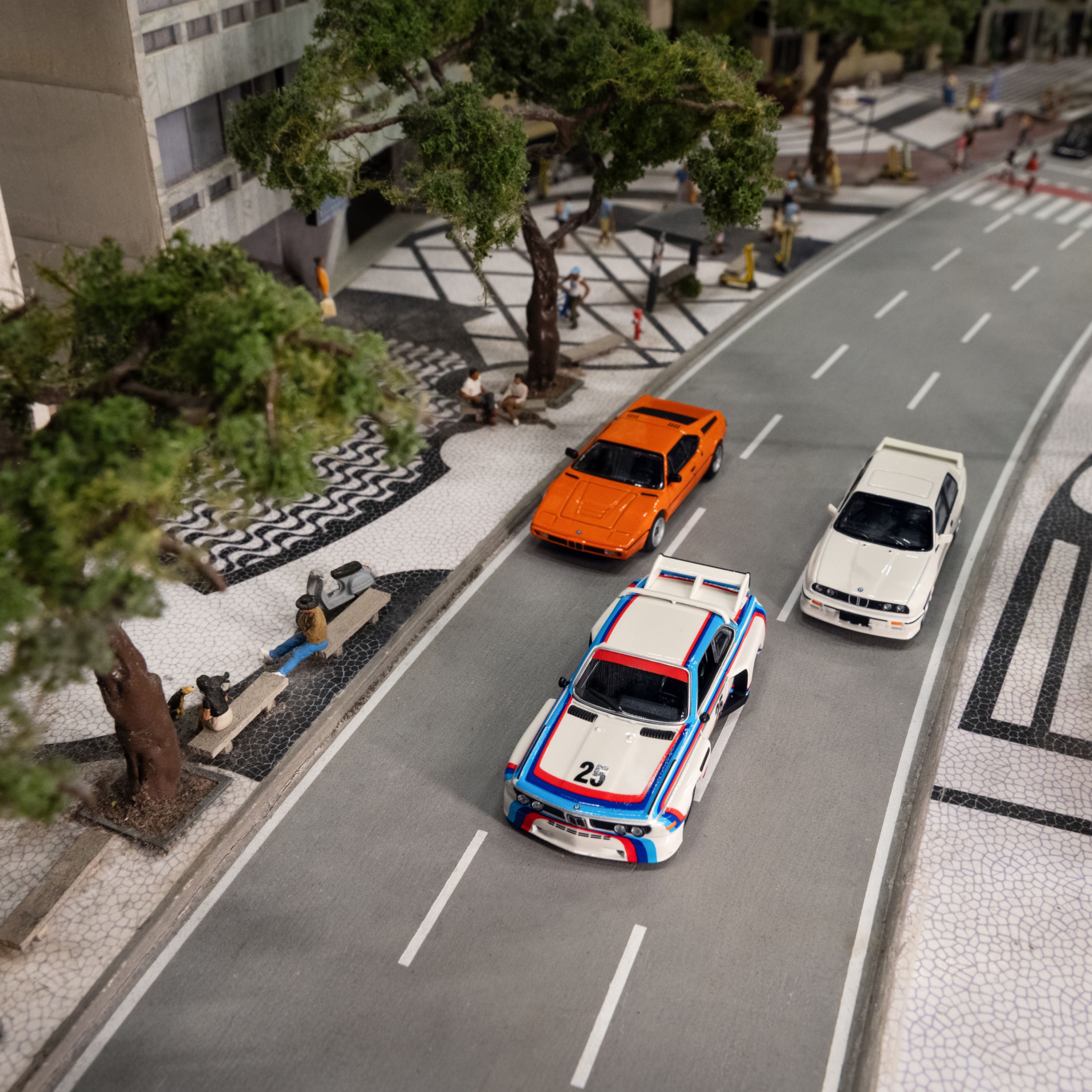 Modellini BMW Lifestyle con una BMW M3 E30, una BMW M1 e una BMW Serie 3 E30 in un ambiente in miniatura 