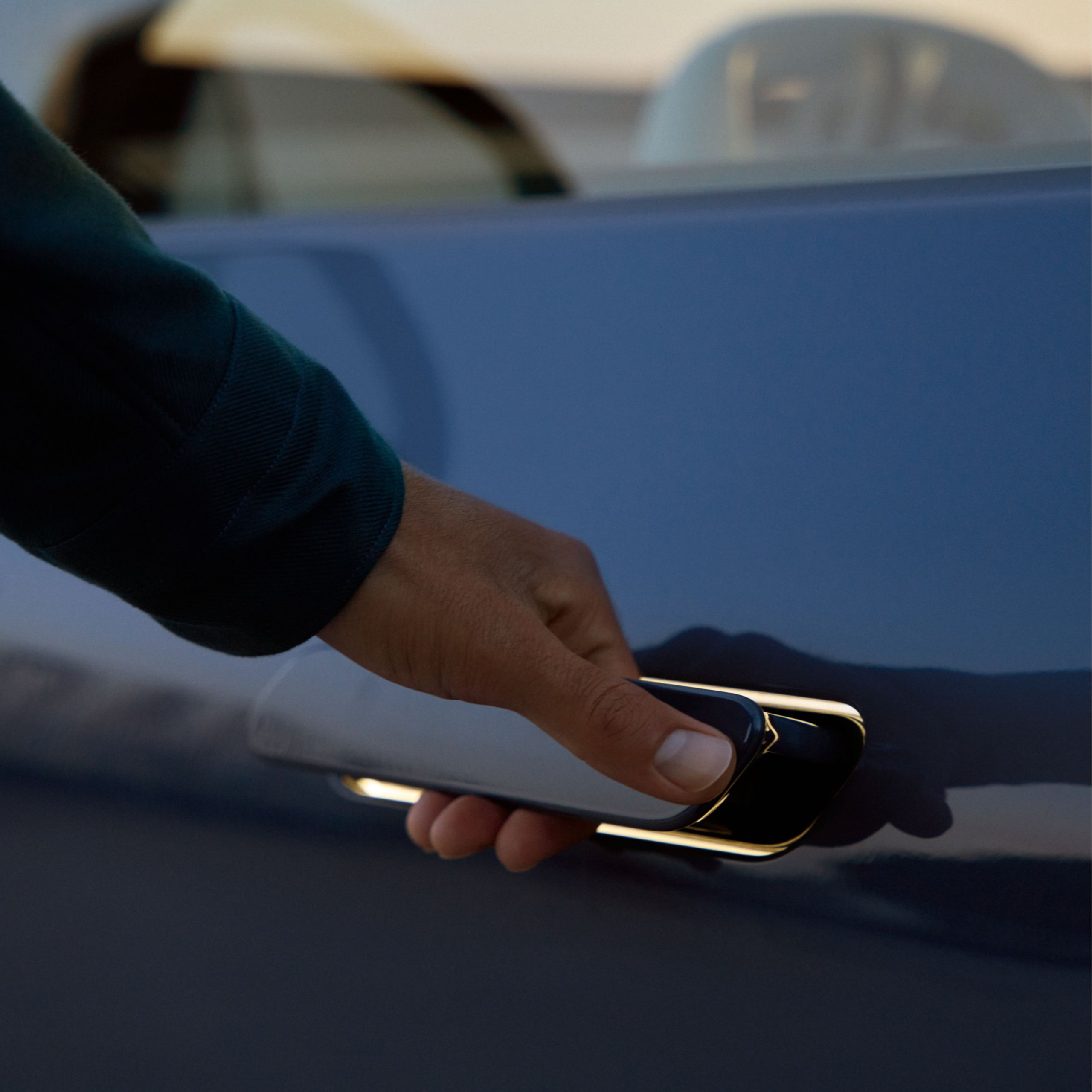 A person is opening the lit door handle of a BMW iX3