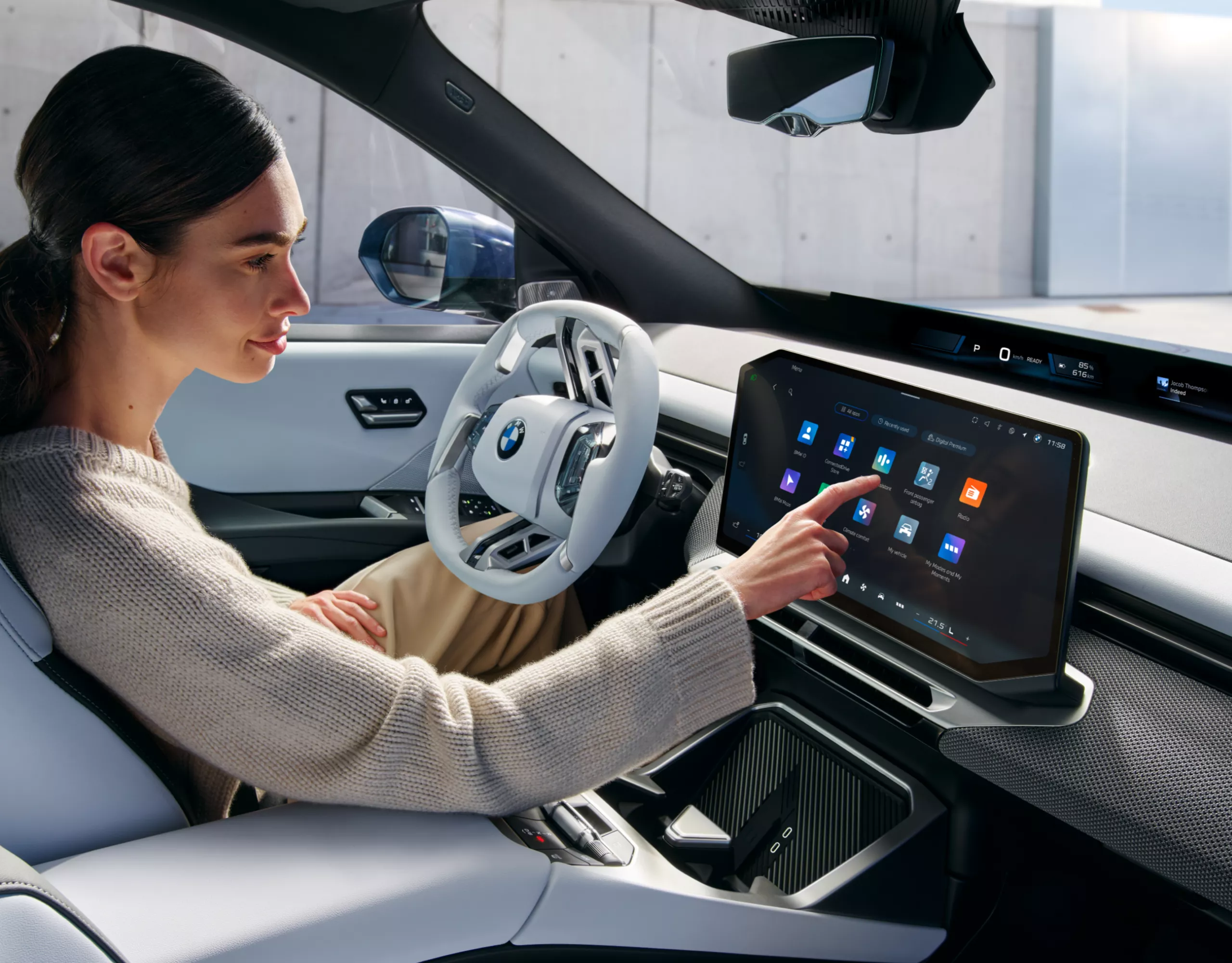 Eine Person bedient das zentrale Display im BMW iX3