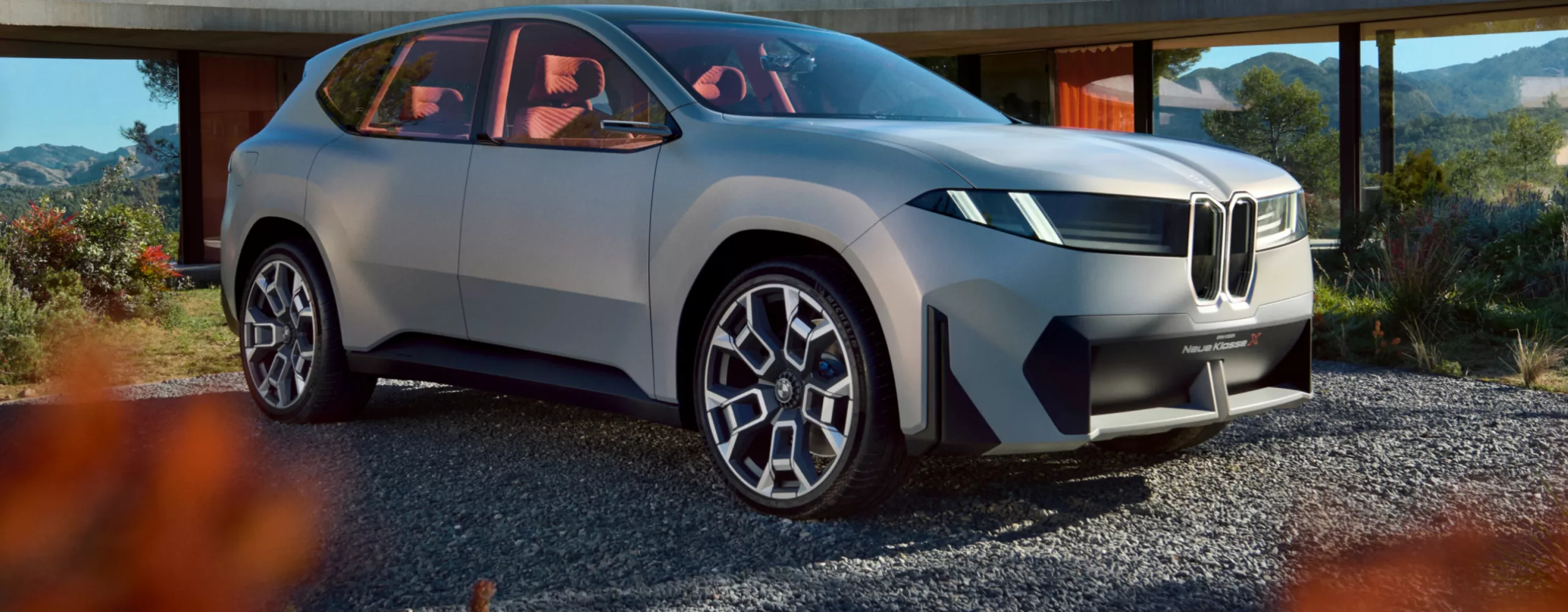 BMW Neue Klasse zaparkowane na dworzu przed minimalistycznym budynkiem