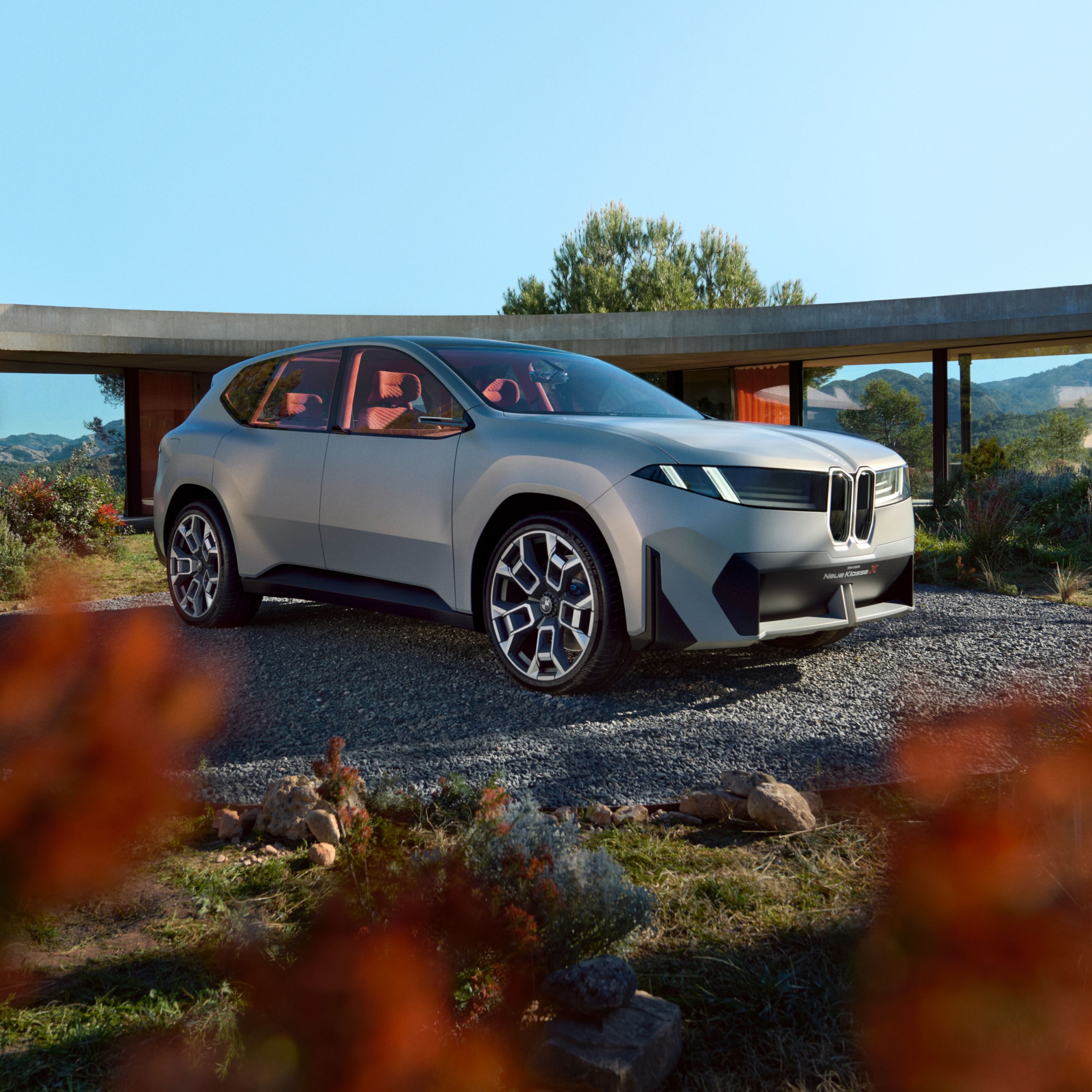 BMW Neue Klasse zaparkowane na dworzu przed minimalistycznym budynkiem