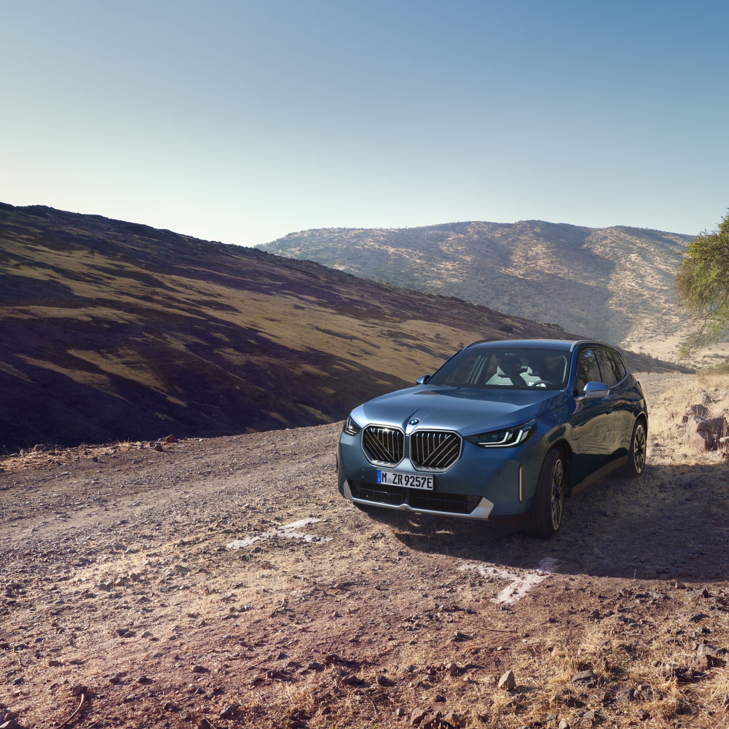  Une BMW X3 hybride rechargeable est exposée au soleil dans un désert montagneux et rocheux