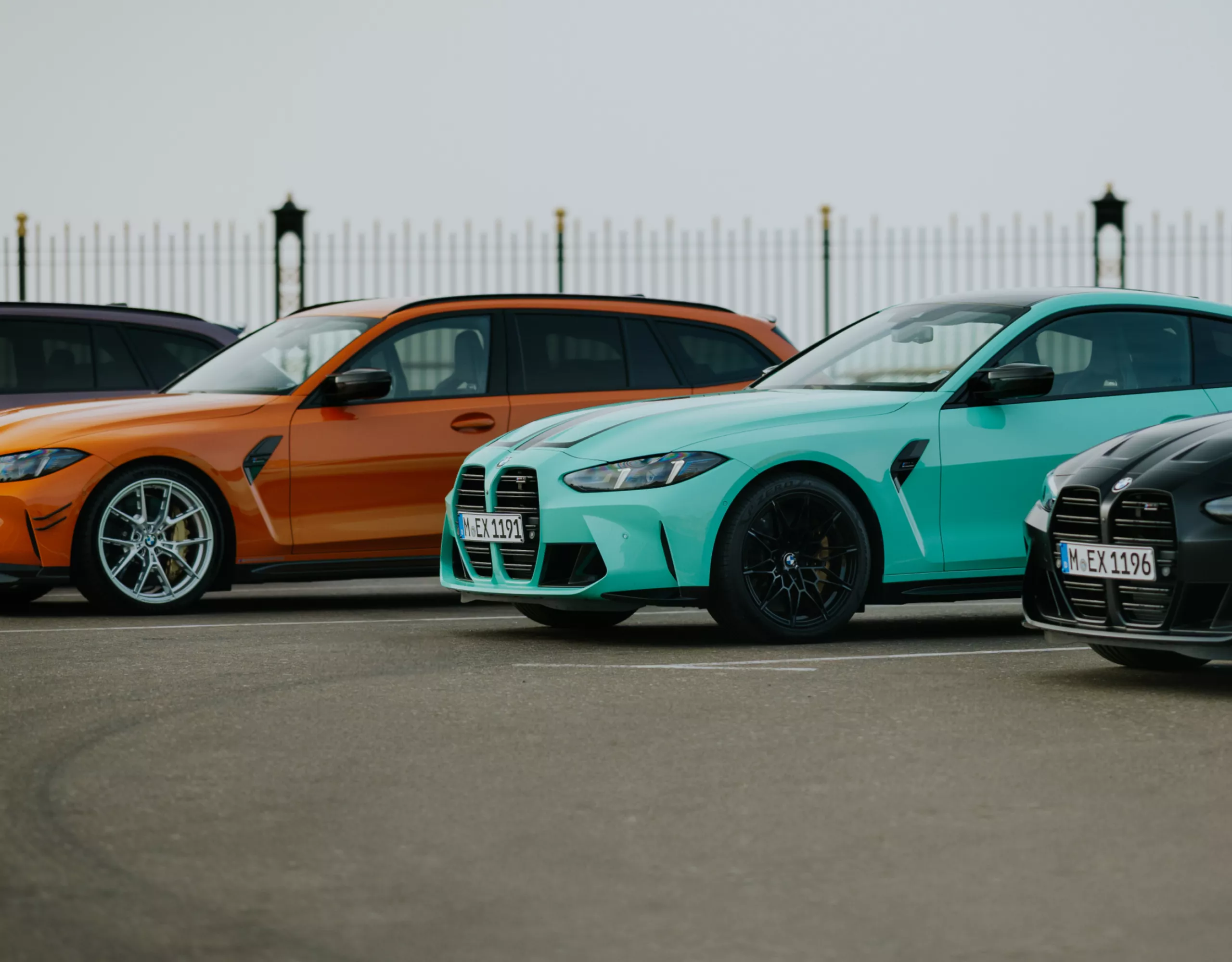 Ein BMW X5 und BMW X6 stehen auf einem Parkplatz vor einem modernen Gebäude