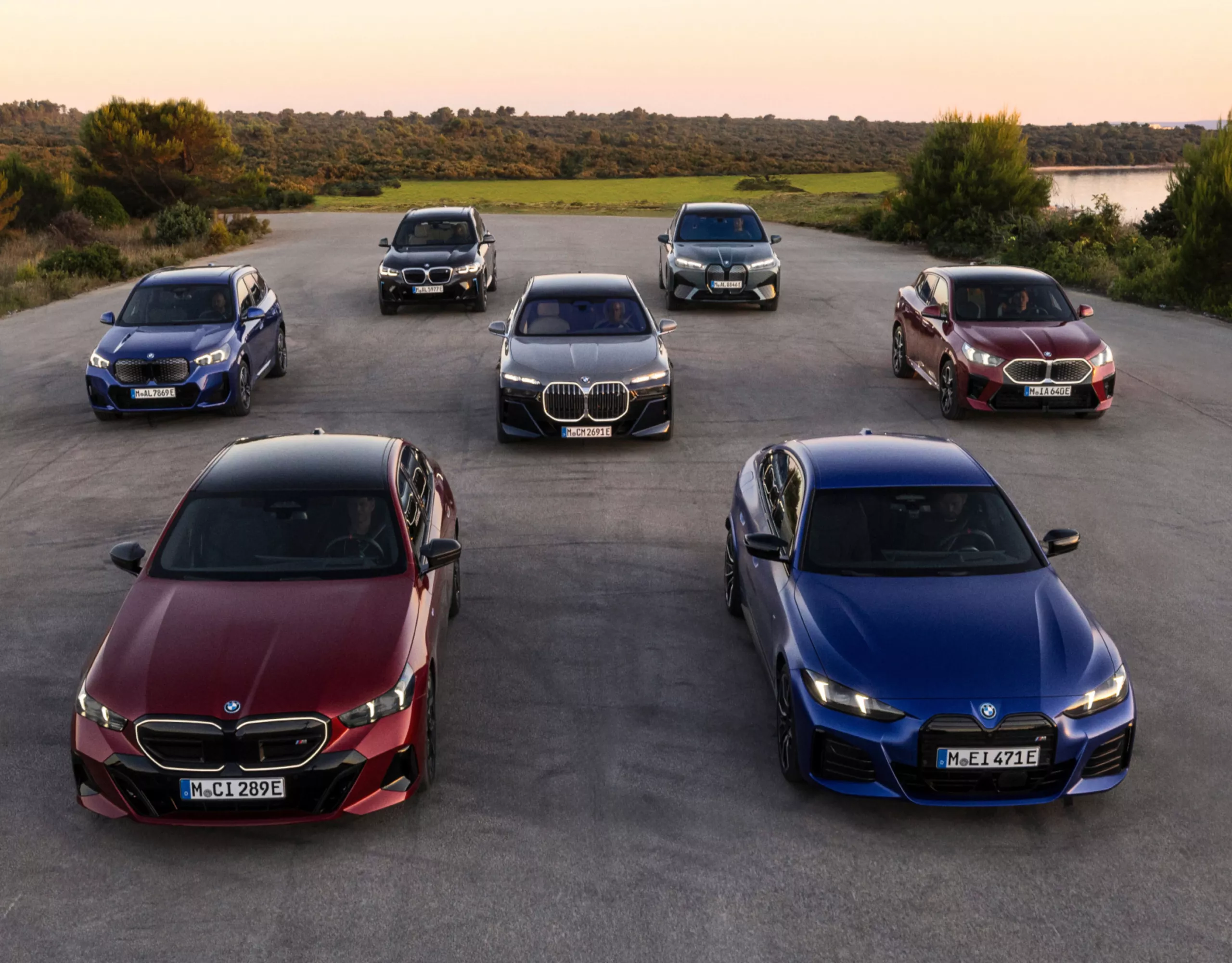 Los vehículos BMW eléctricos aparcados uno junto al otro delante de un lago