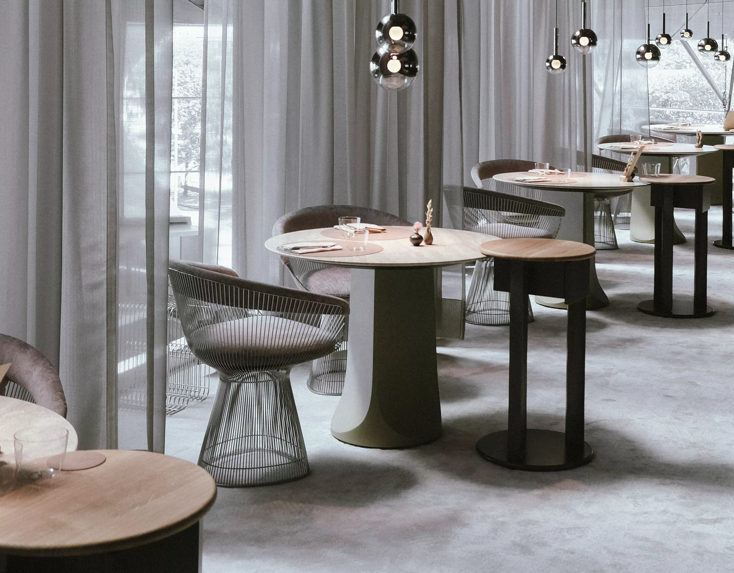 Exklusiv eingerichtetes, modernes Restaurant mit runden Tischen, eleganten Stühlen und sanfter Beleuchtung