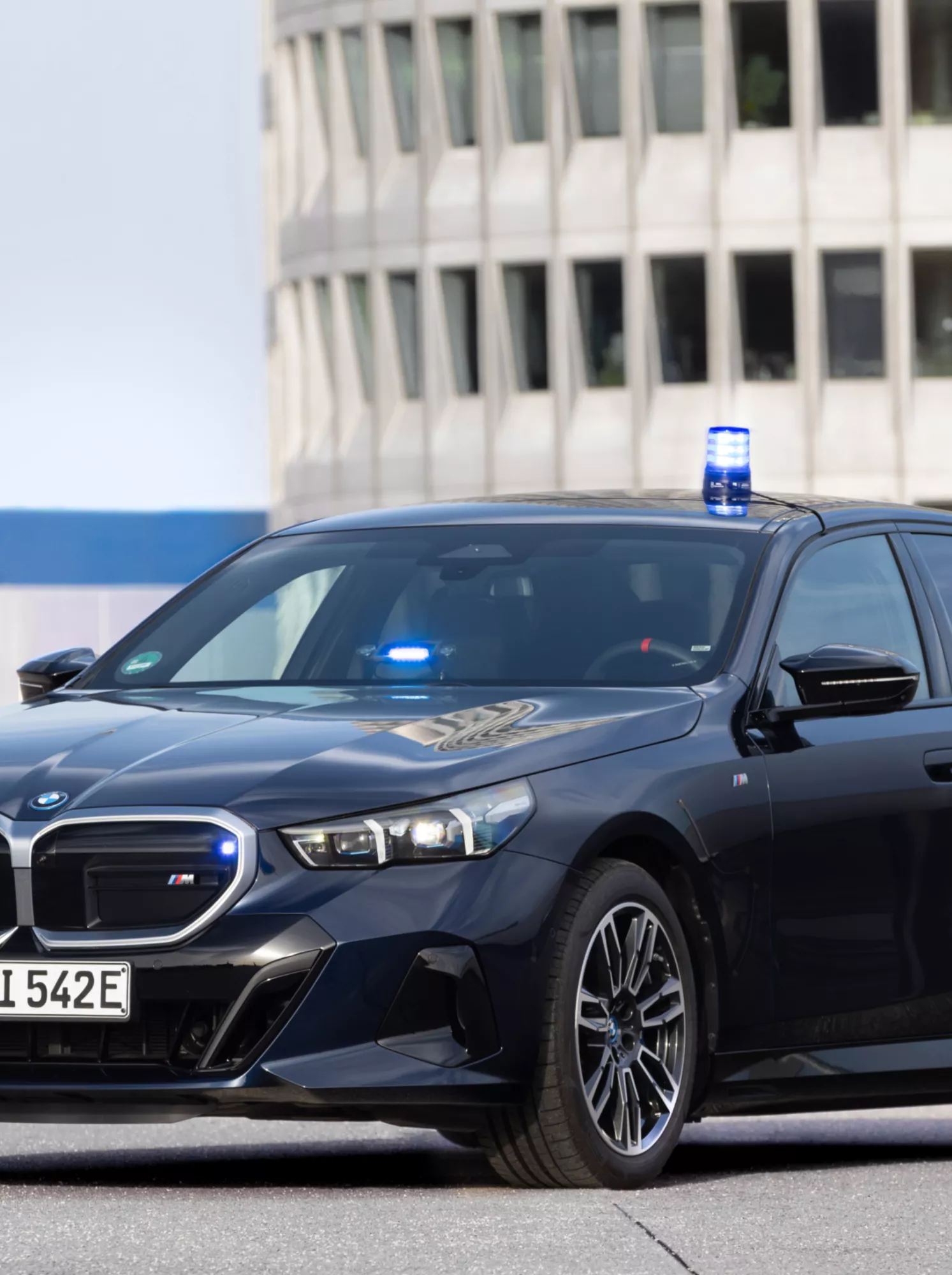 Een BMW Interventievoertuig staat op een parkeerplaats voor een kantoorgebouw