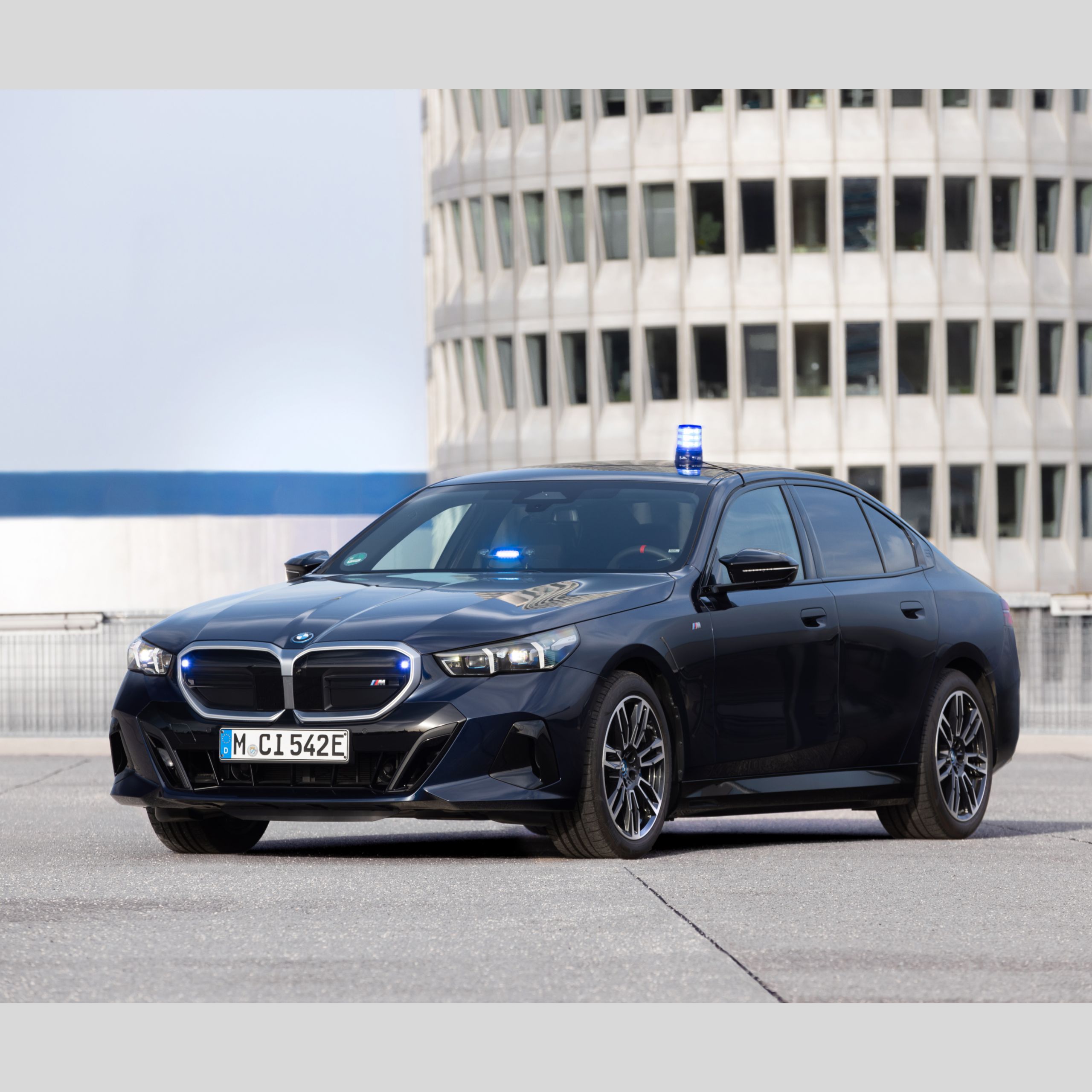 Ein BMW Einsatzfahrzeug steht auf einem Parkplatz vor einem Bürogebäude