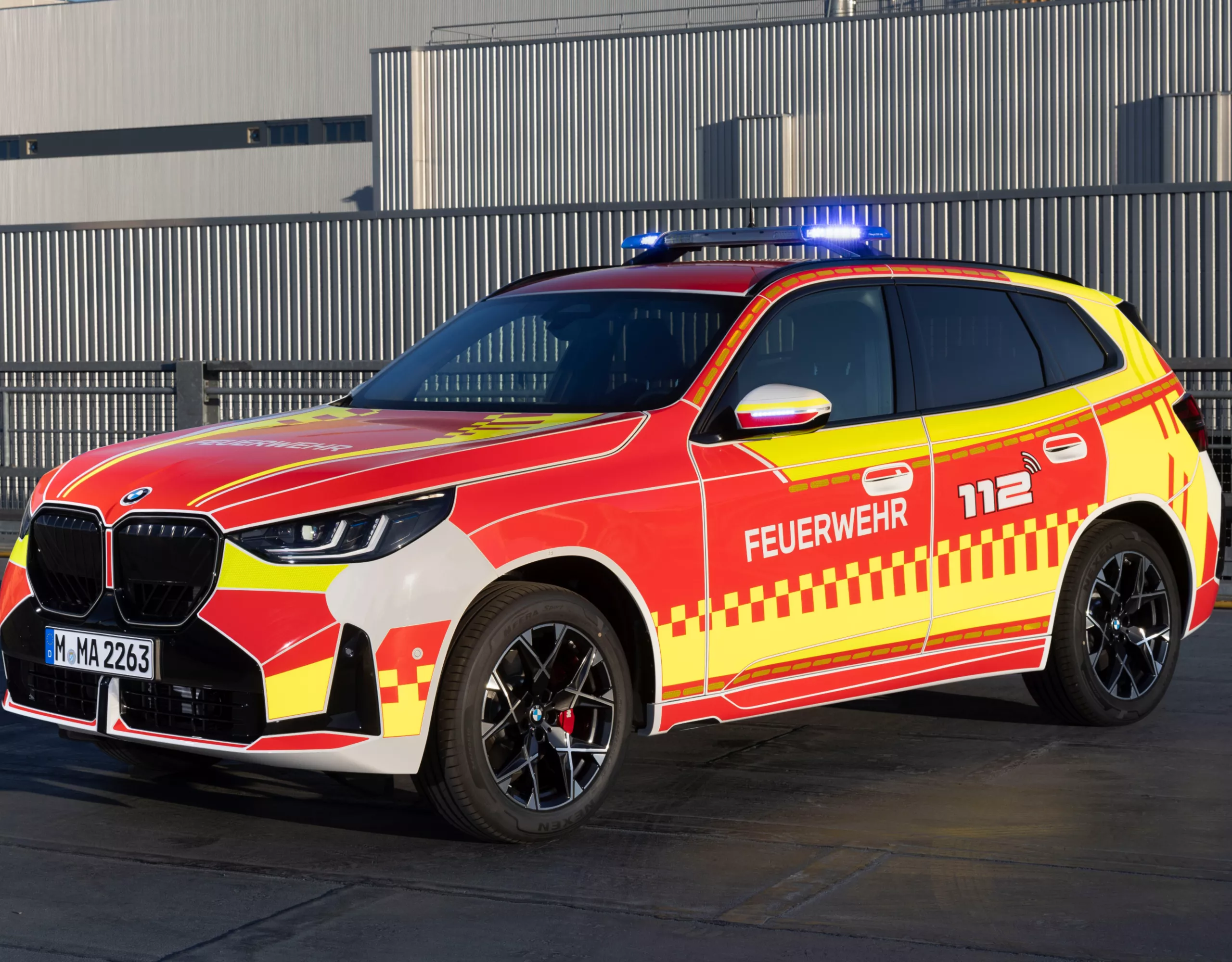 A BMW fire-fighting vehicle parked in front of an industrial building