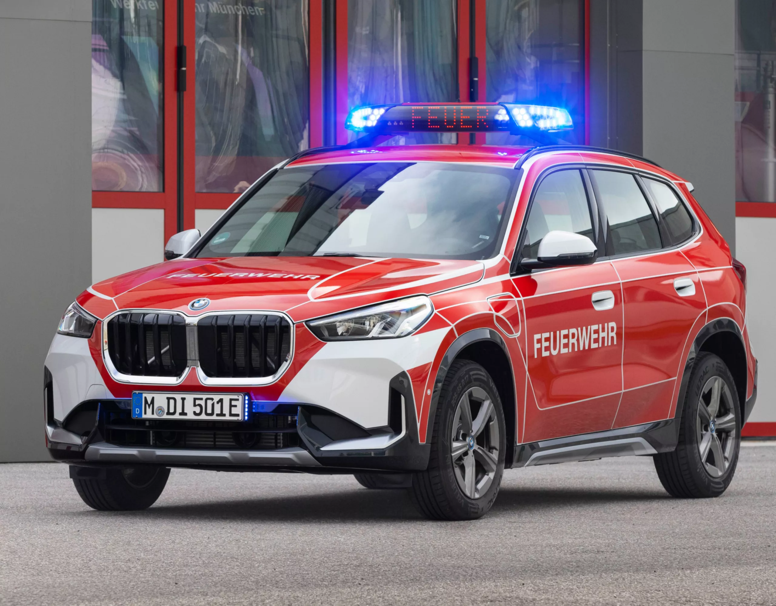 Een BMW brandweerwagen staat voor een gebouw