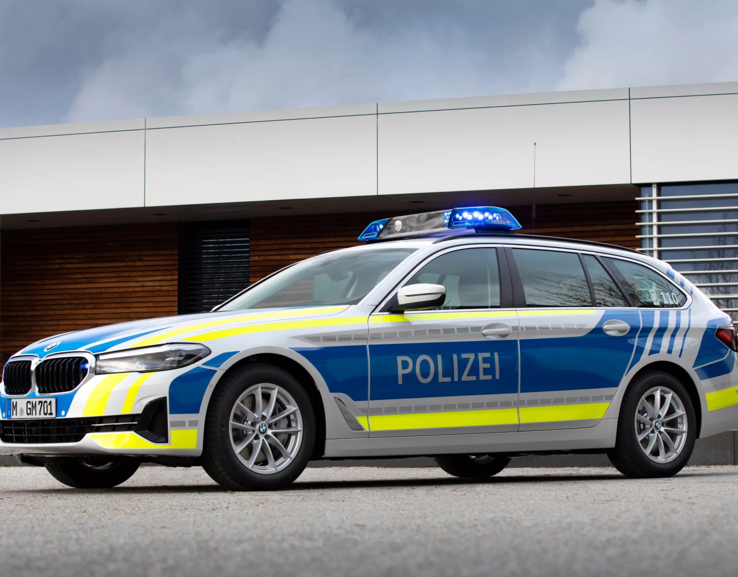 Een BMW politiewagen staat voor een gebouw