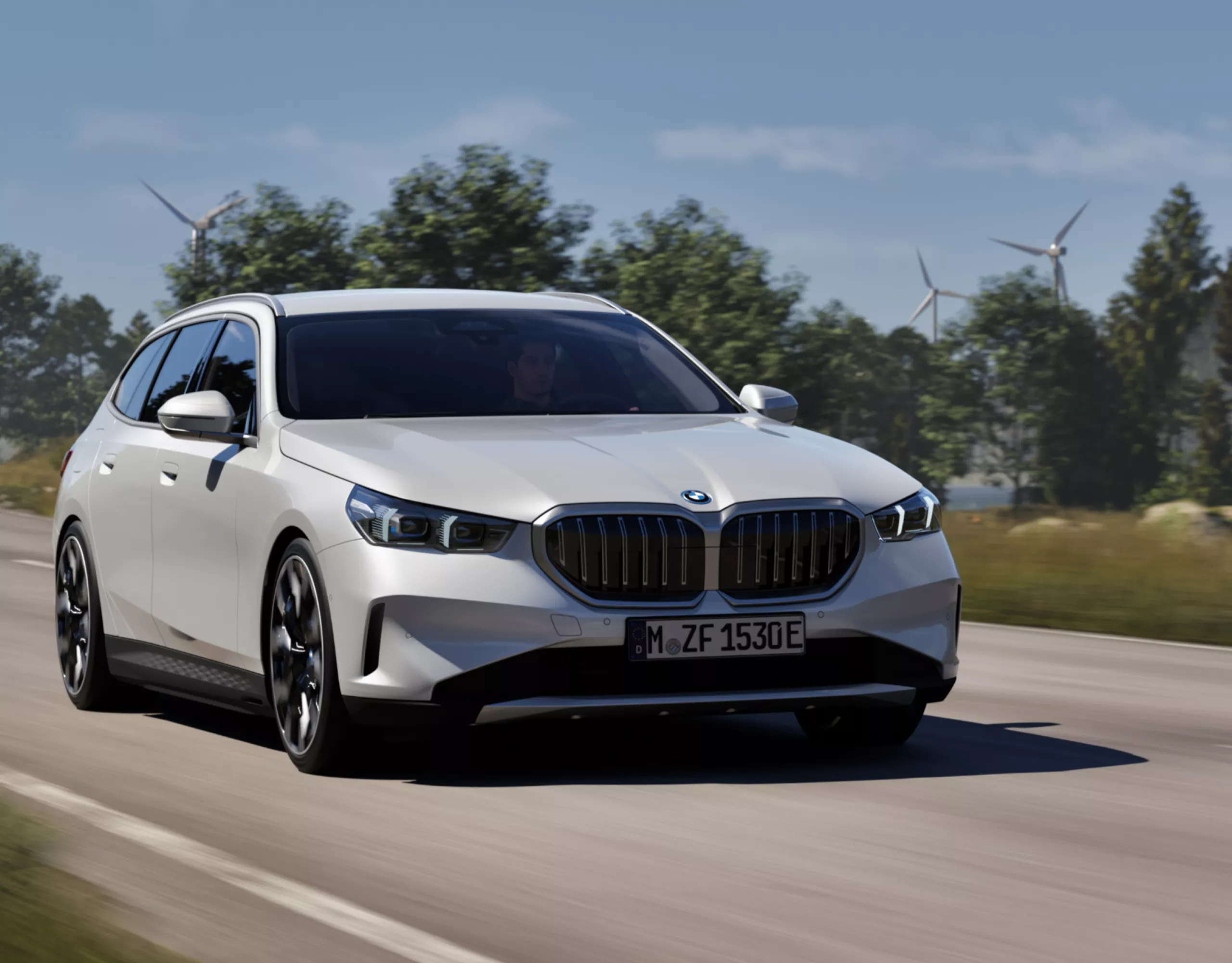 A BMW drives along a road