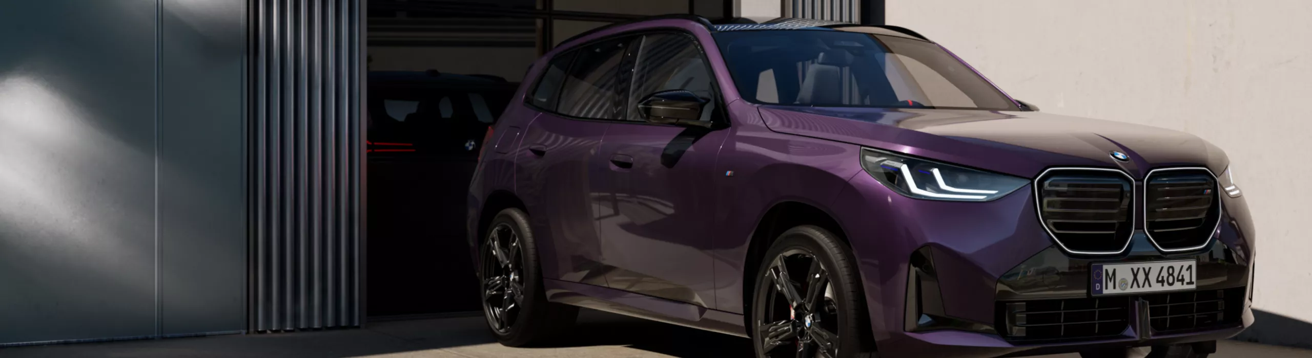 Un veicolo blindato SUV BMW fermo davanti a un garage