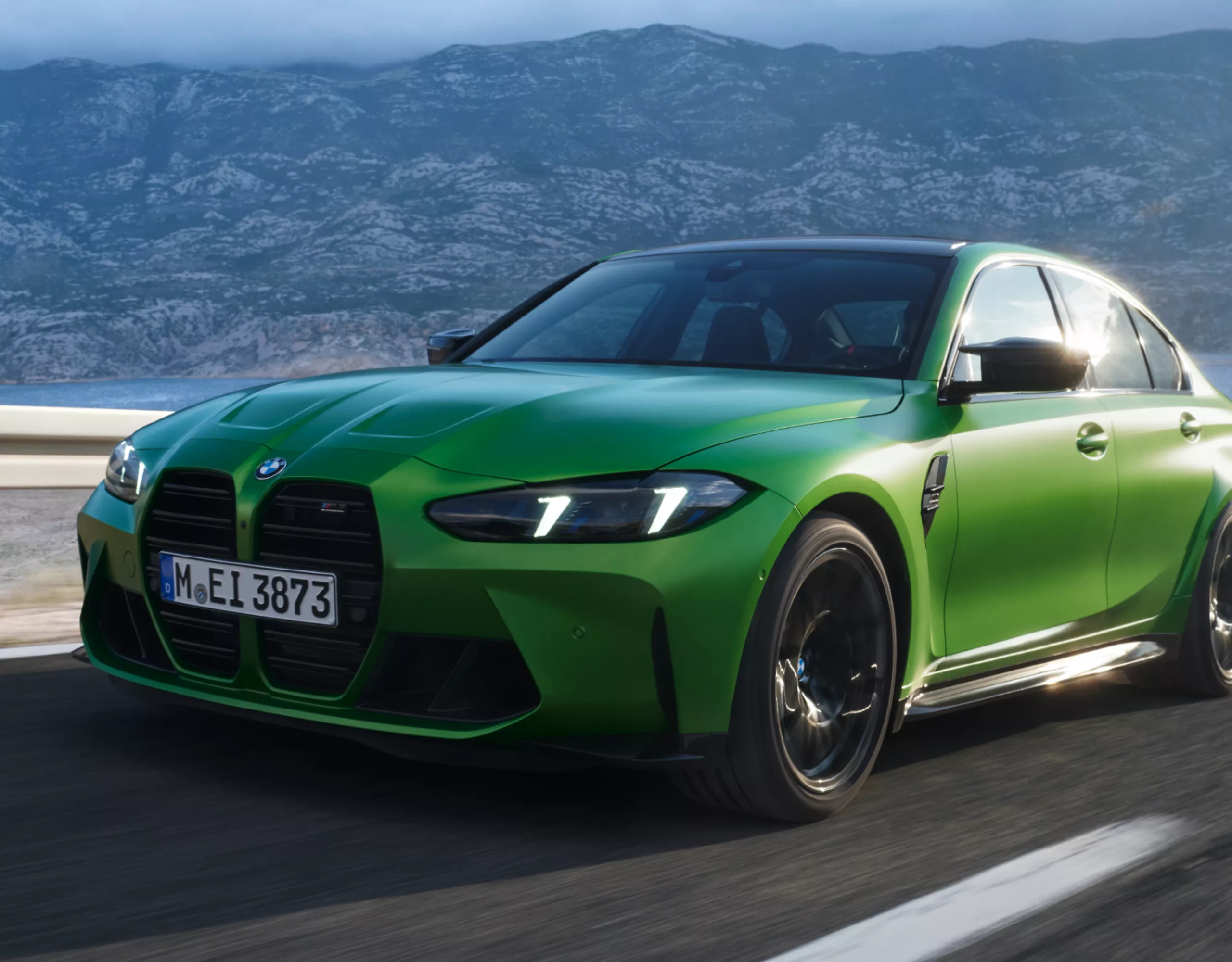 Una BMW in un parcheggio con montagne e nuvole spettacolari sullo sfondo