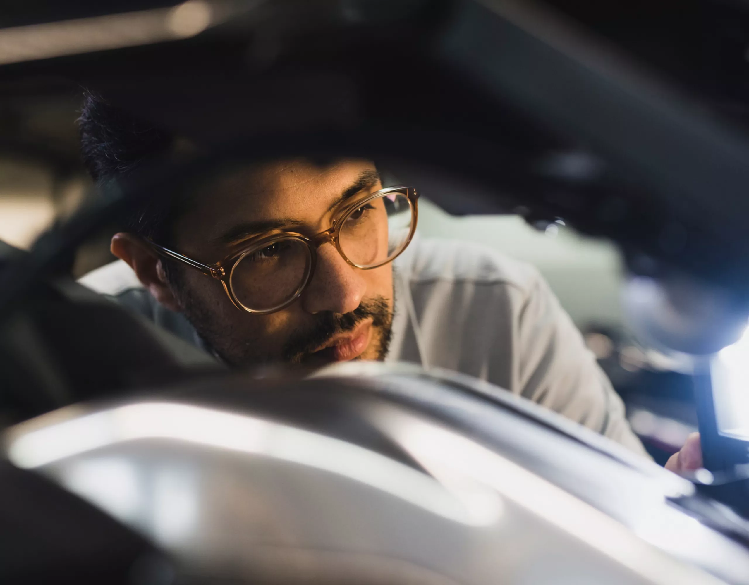 A man looks intently at a vehicle detail