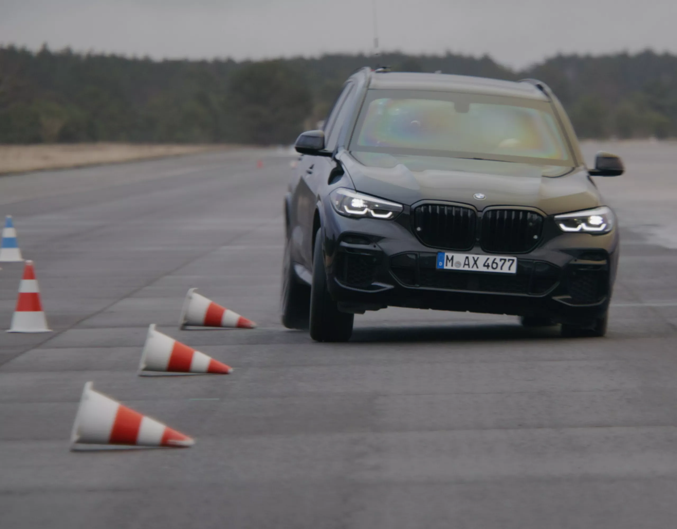 A BMW in a driver training course on a test track with traffic cones