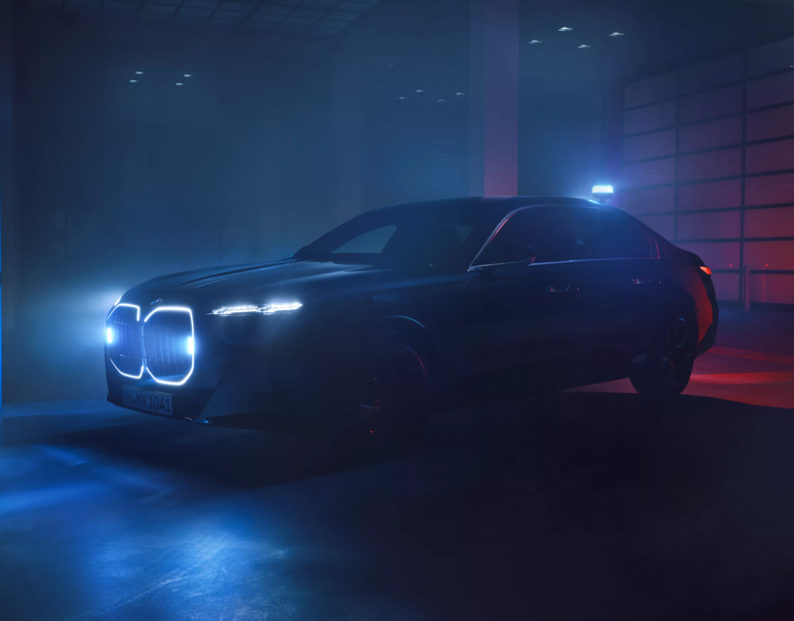 Ein BMW Sonderschutzfahrzeug mit beleuchteter Niere steht in einem dunklen Innenraum