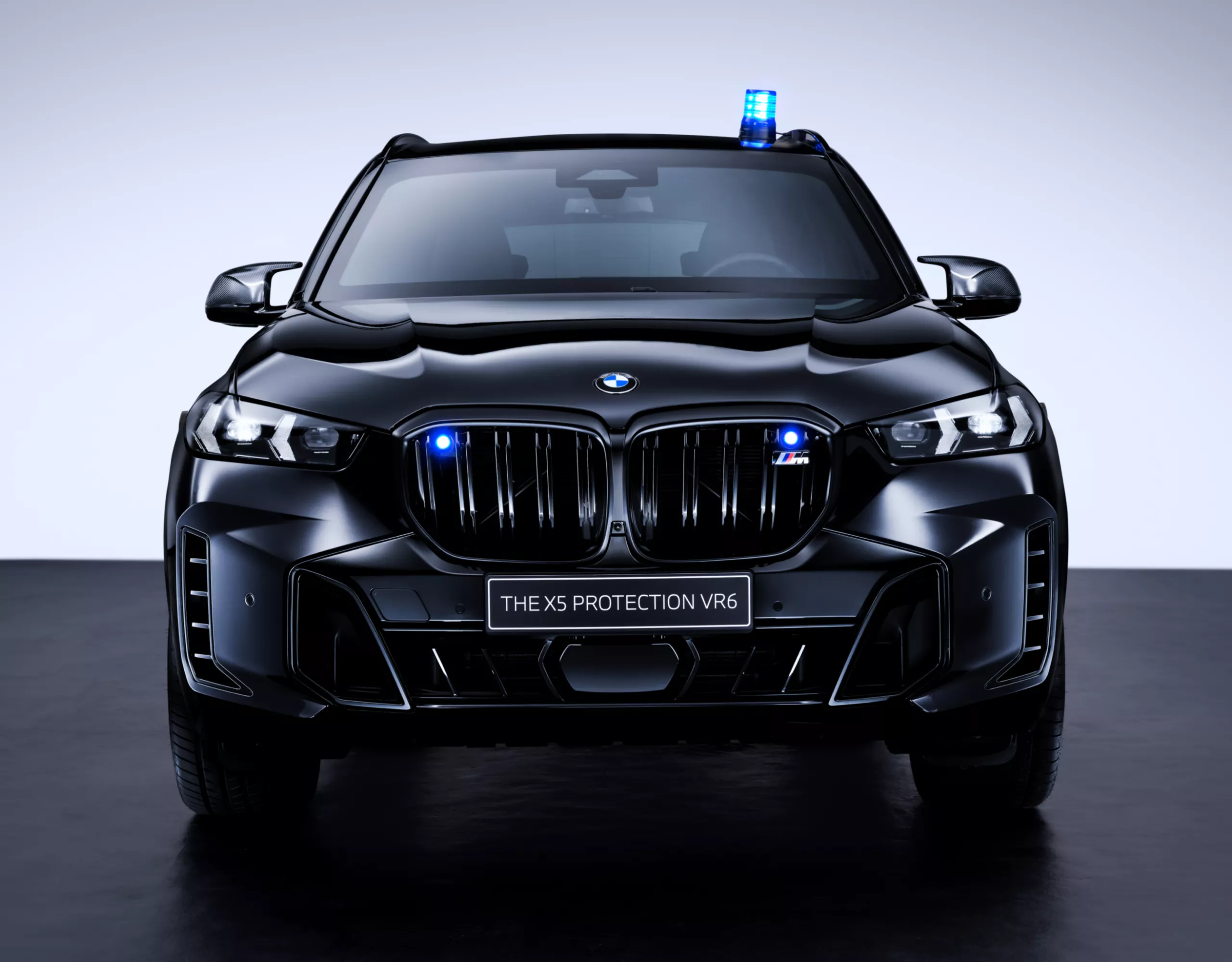 A BMW Protection Vehicle from the front with additional blue flashing lights on the kidney grille and blue signal light on the roof