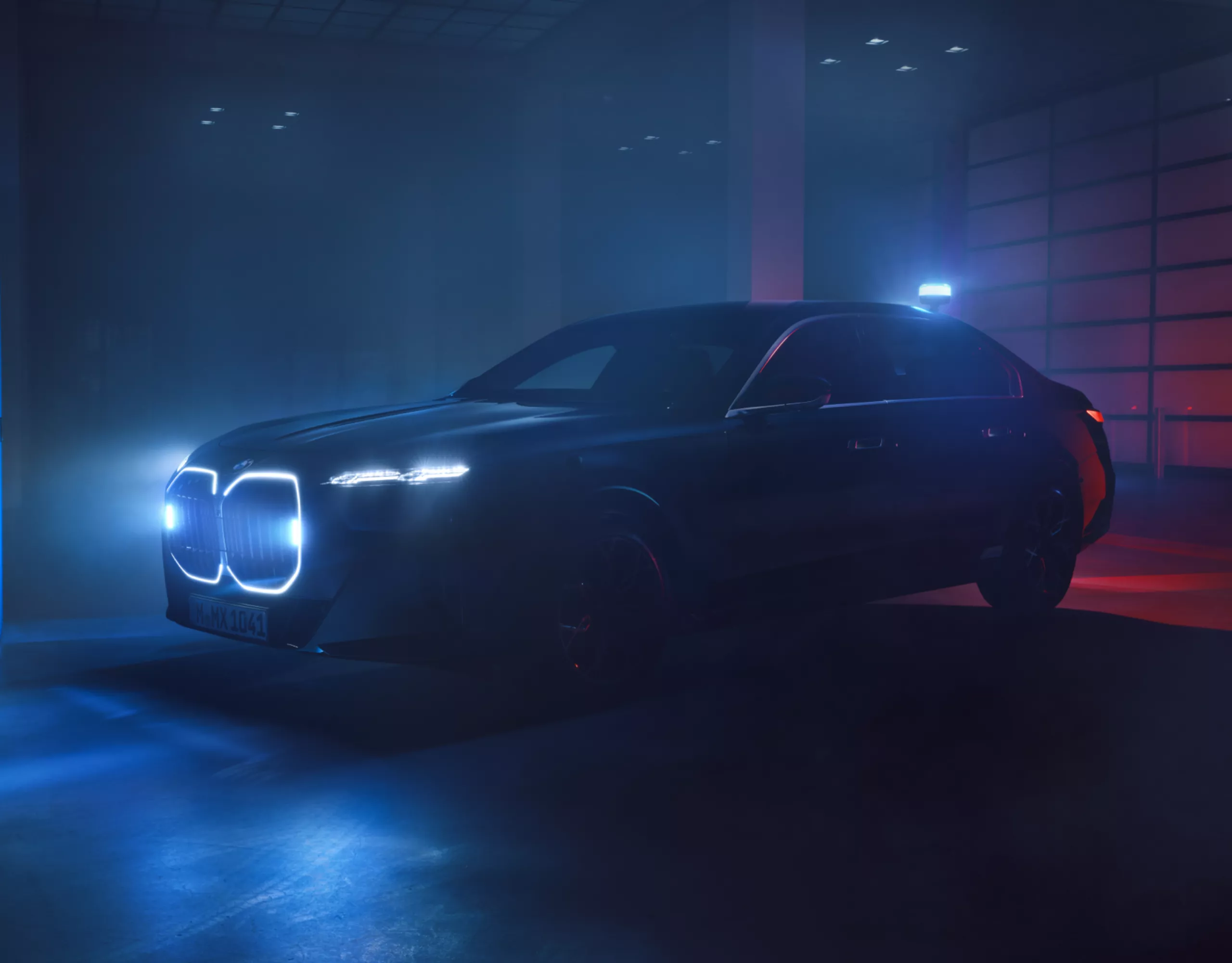 Ein BMW Sonderschutzfahrzeug mit beleuchteter Niere steht in einem dunklen Innenraum