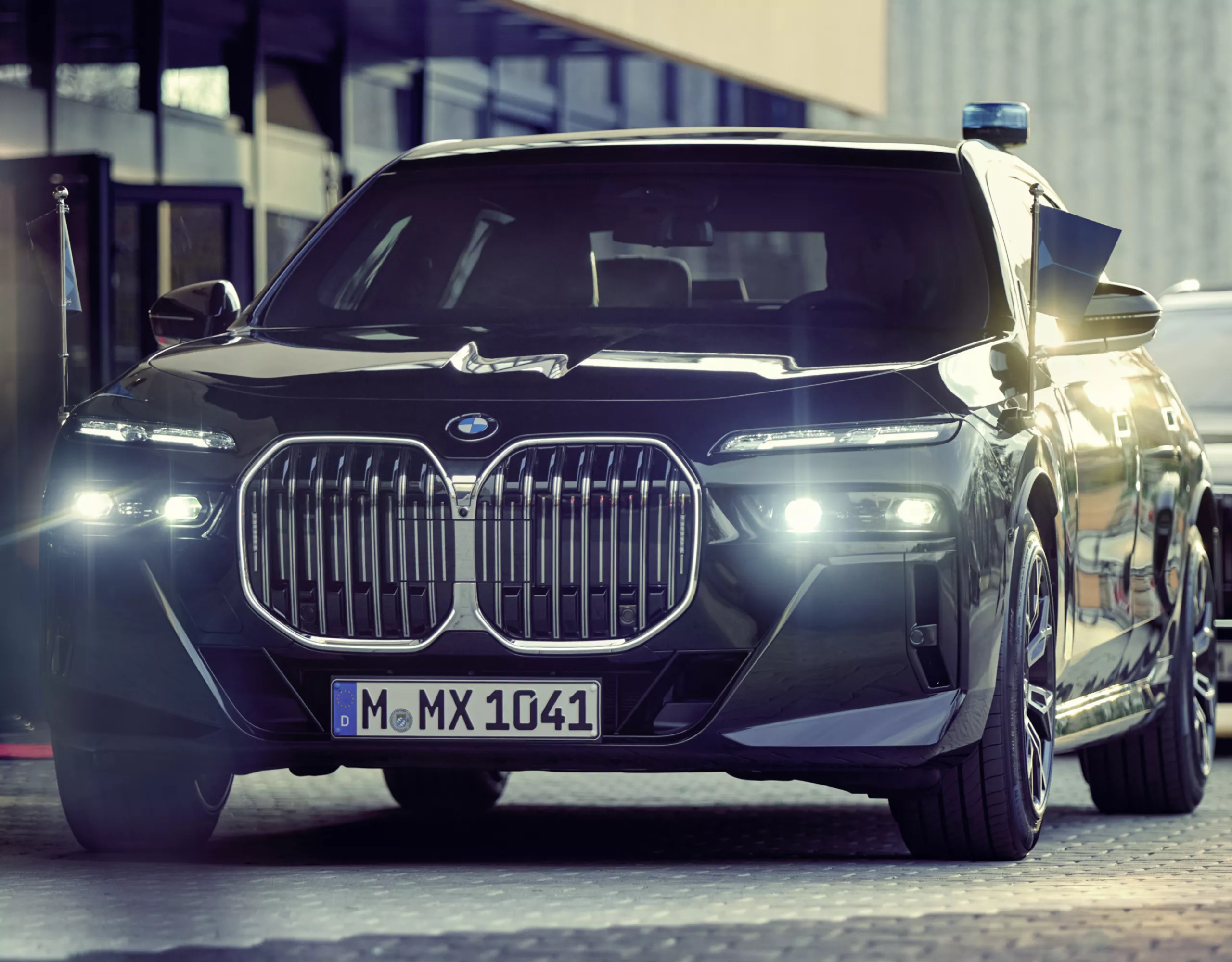 A BMW Protection Vehicle with penant holder seen from the front with a building behind