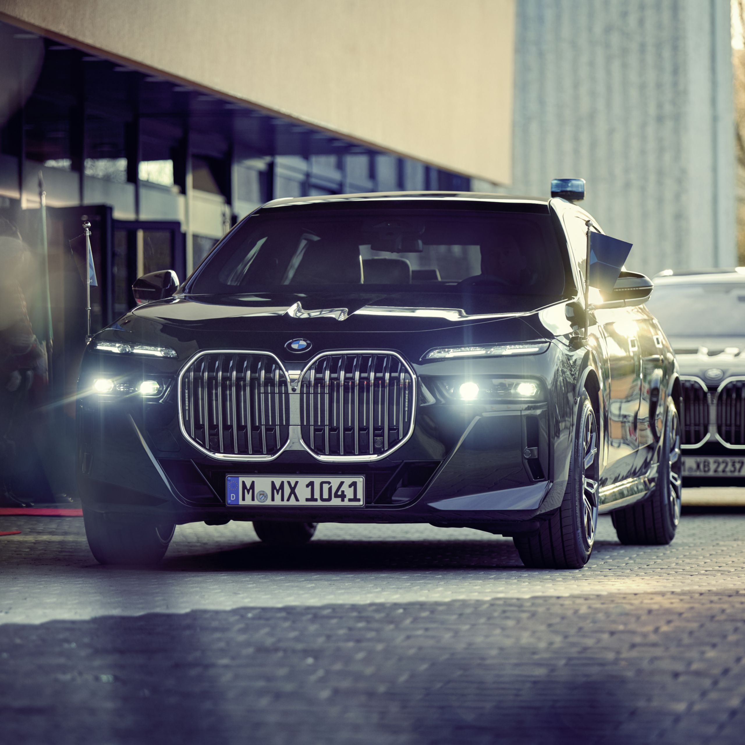 BMW biztonsági jármű zászlótartóval, elölről nézve, a háttérben épülettel