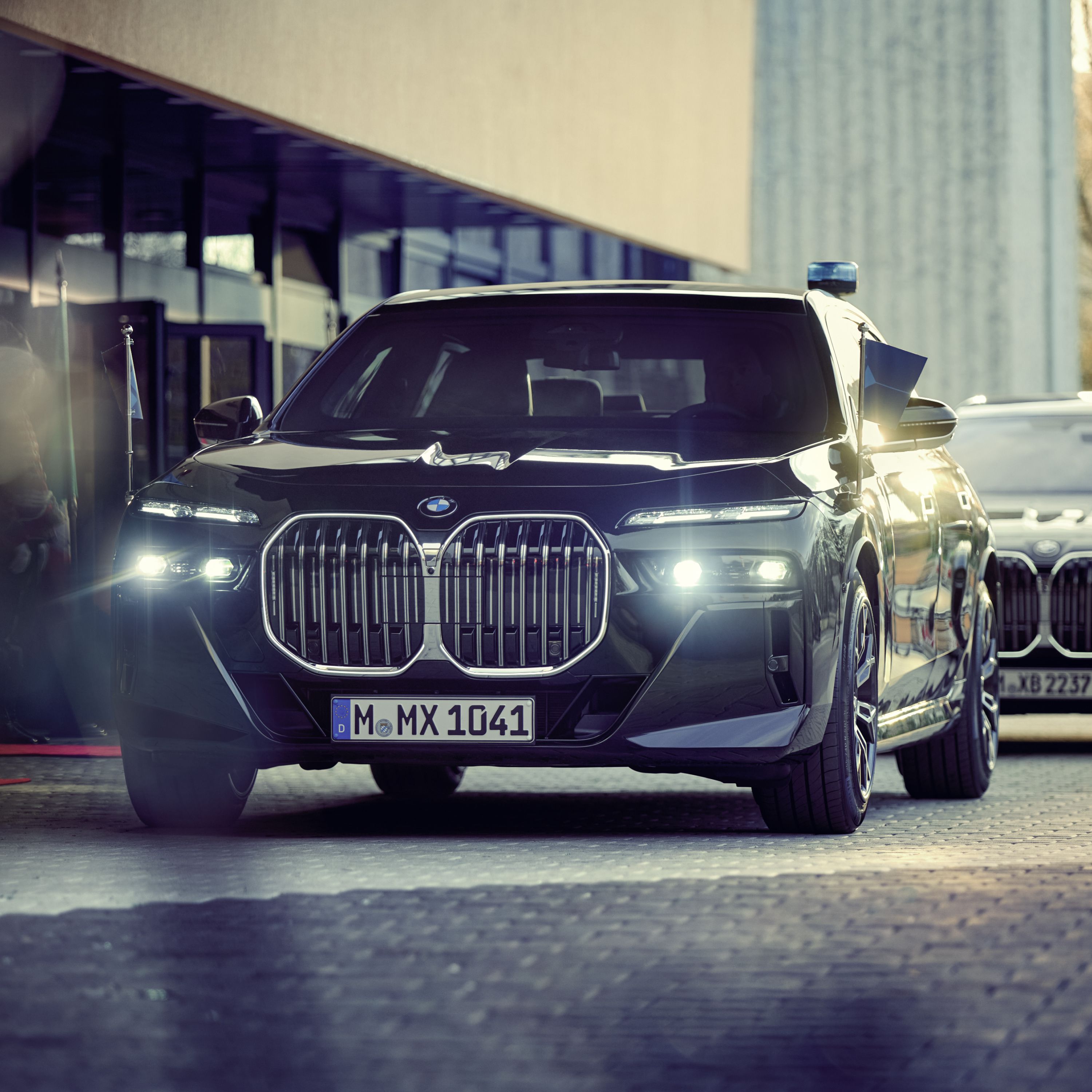 A BMW Protection Vehicle with penant holder seen from the front with a building behind