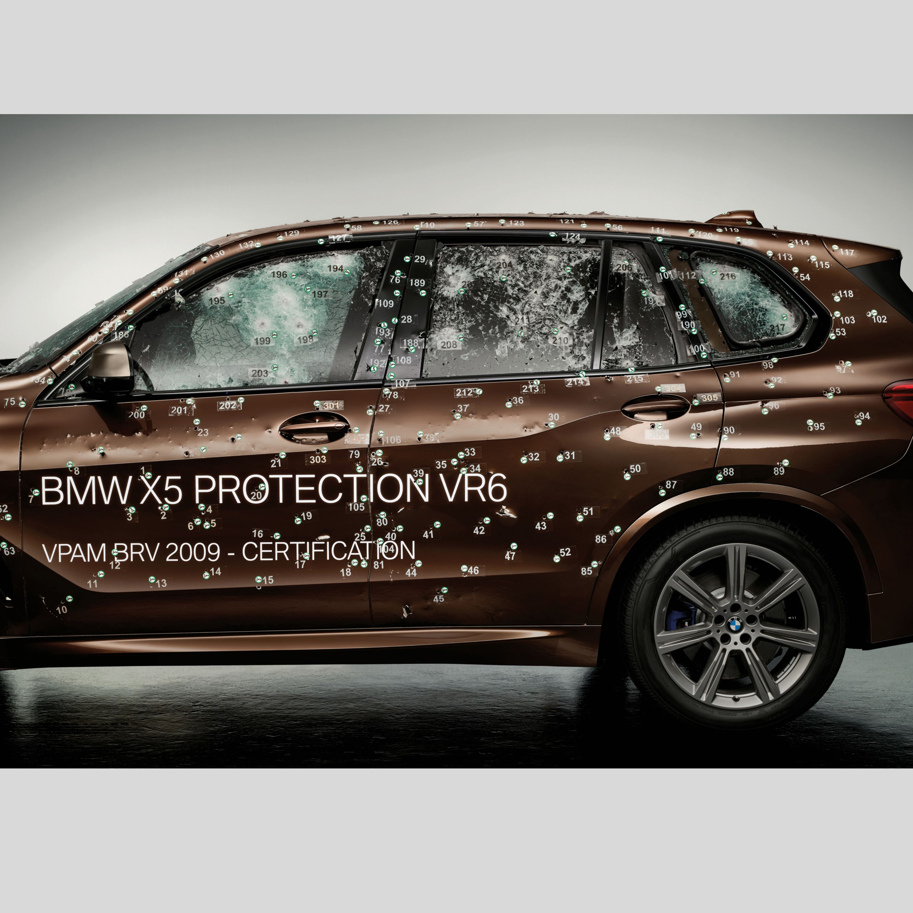 A partial image of a BMW Protection Vehicle with bullet holes, having undergone a ballistic test