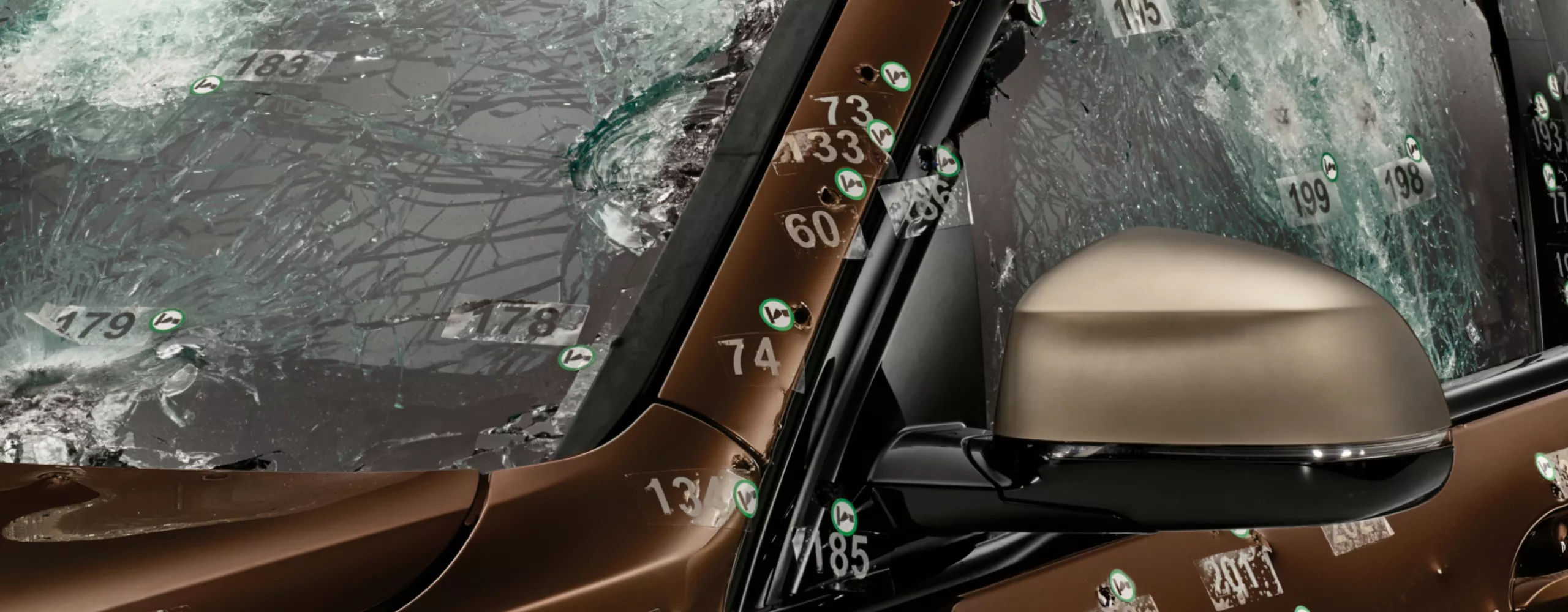 Close-up of the windscreen and side window with protective glass and bullet holes after a ballistic test 