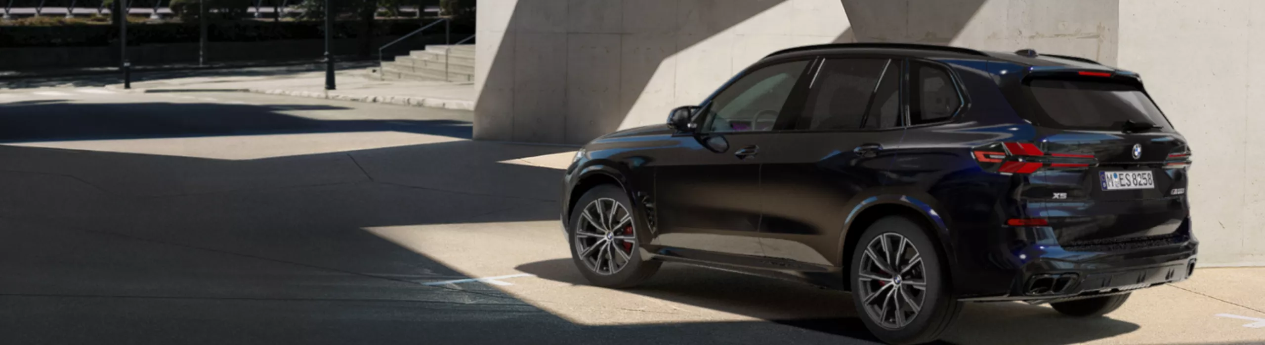 Un véhicule de protection spéciale BMW est stationné à côté d’un mur en béton