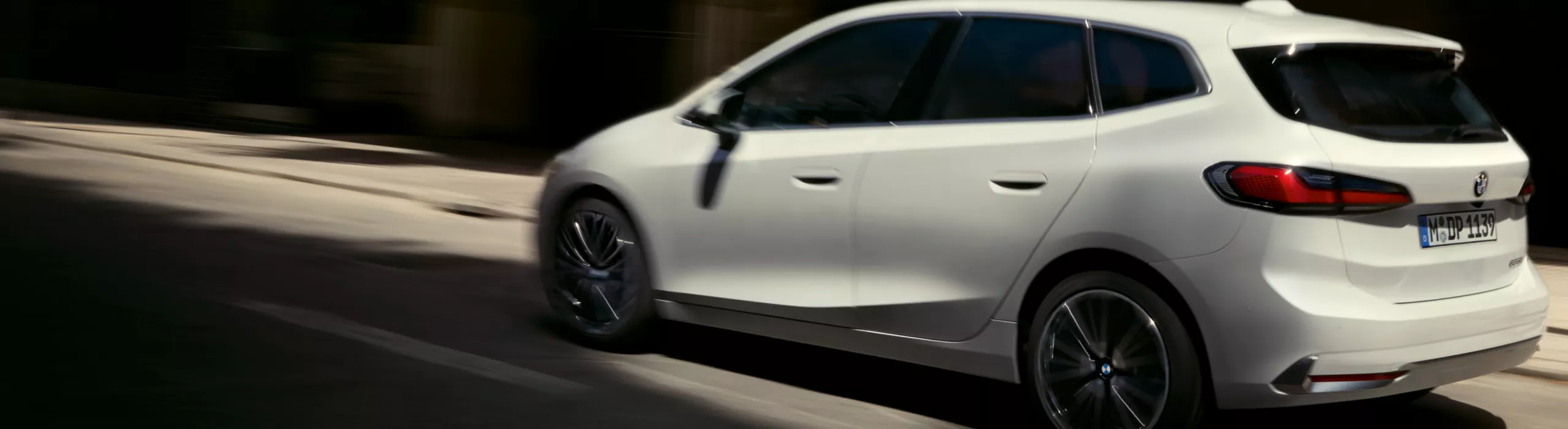 BMW 2er Active Tourer fährt vor einer Hecke entlang