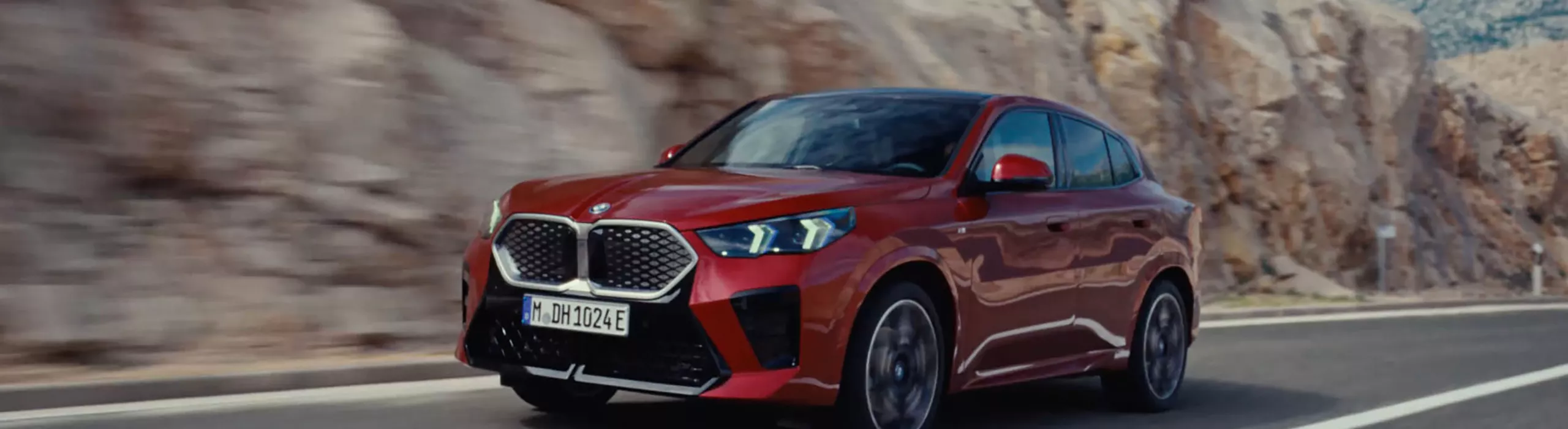 Video loop of the exterior view of the BMW iX2 xDrive30 in Dragonfire Red with light alloy wheels 