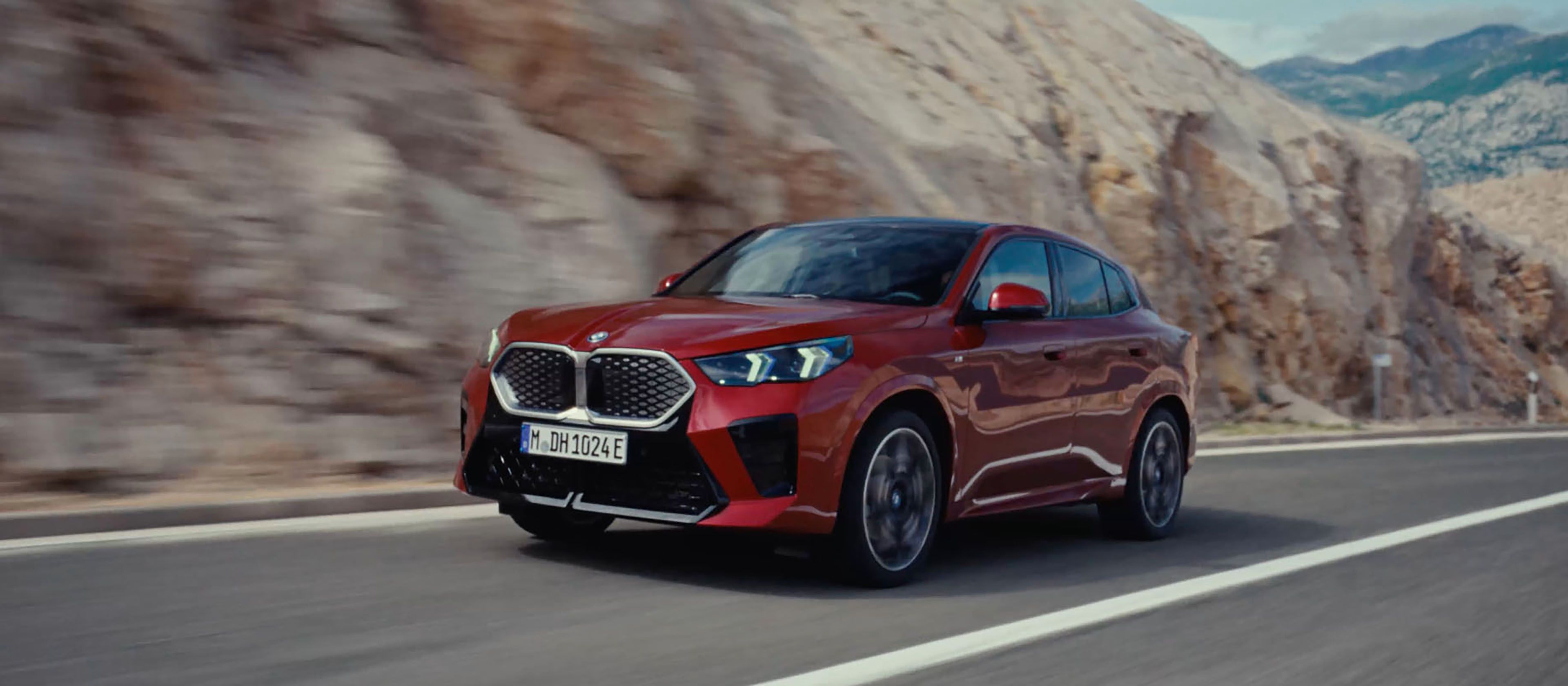 Video loop of the exterior view of the BMW iX2 xDrive30 in Dragonfire Red with light alloy wheels 