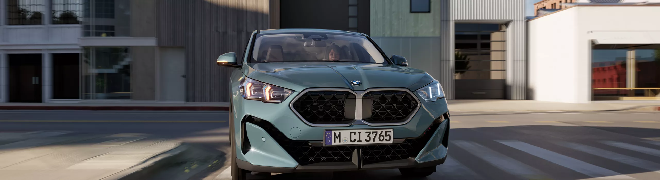 BMW X2 sDrive 20i exterior low angle shot front right, showcasing the car with light alloy wheels and lights engaged
