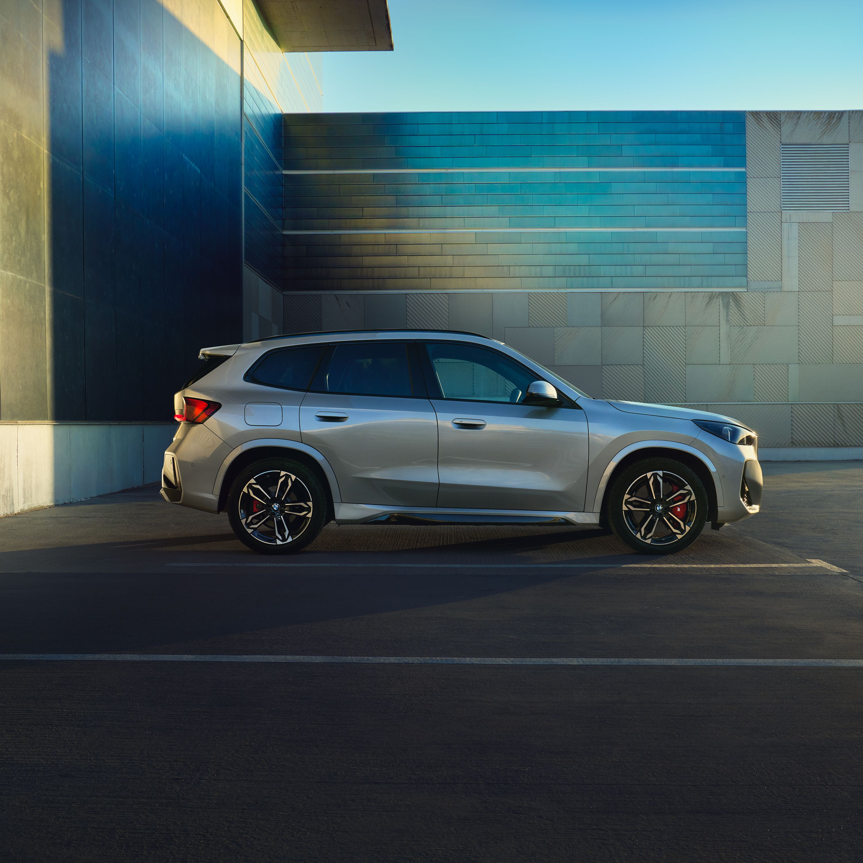Widok z boku BMW X1 w wersji hybrydowej plug-in pokazuje jego smukłą sylwetkę.
